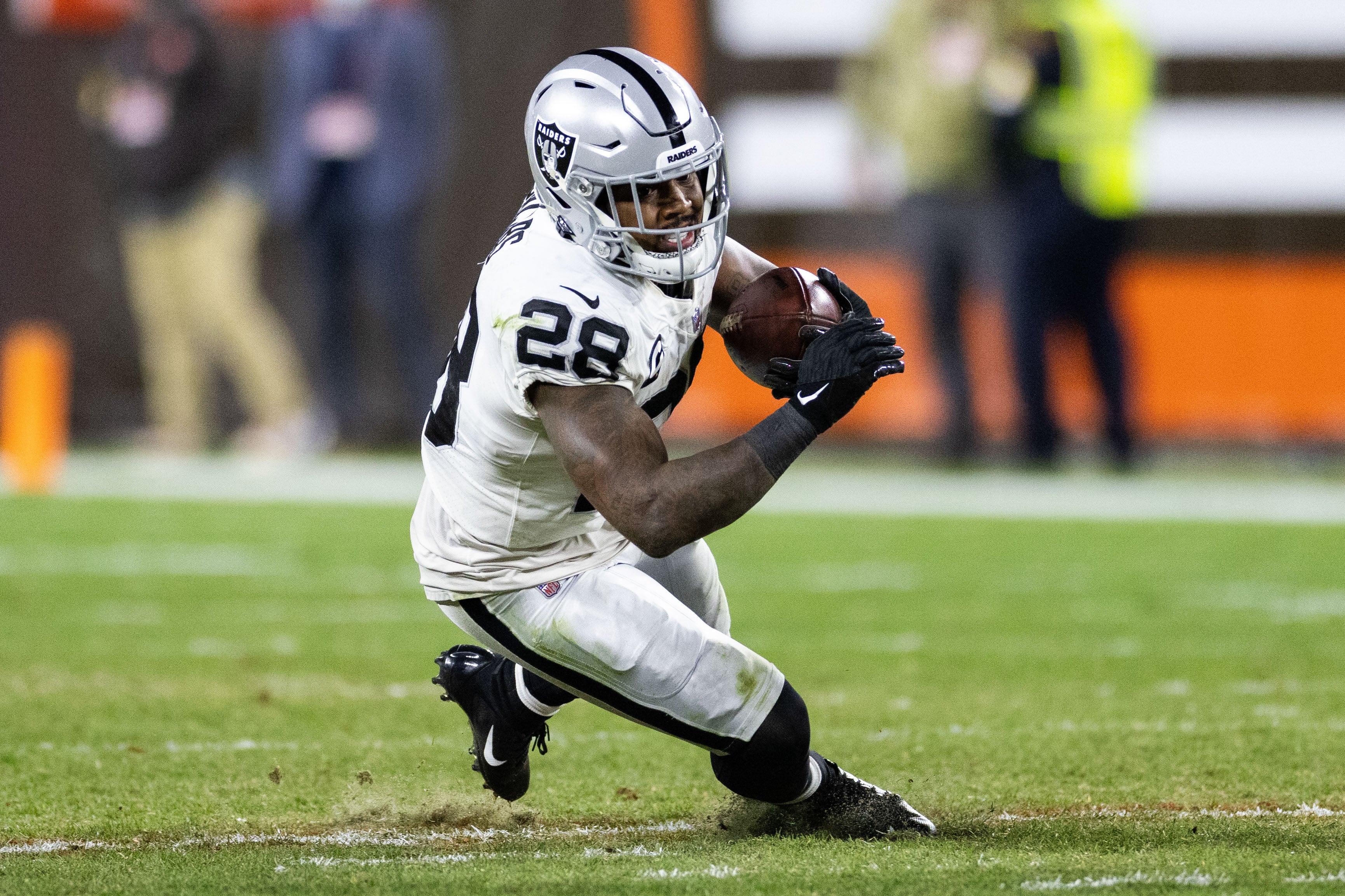 Dec 20, 2021; Cleveland, Ohio, USA; Las Vegas Raiders running back Josh Jacobs (28) slips as he runs the ball against the Cleveland Browns during the fourth quarter at FirstEnergy Stadium.