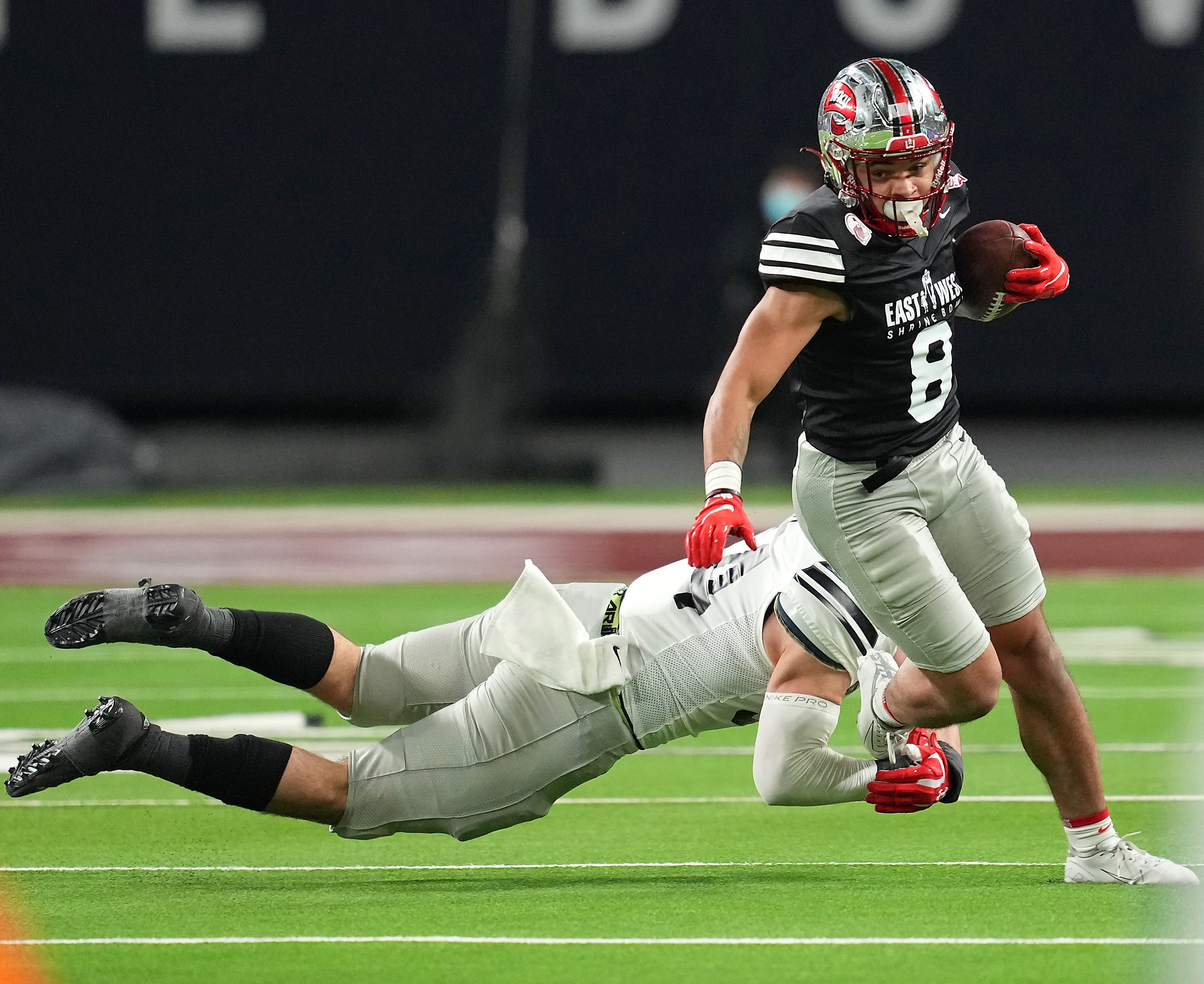 Feb 3, 2022; Las Vegas, NV, USA; West wide receiver Jerreth Sterns of Western Kentucky (8) slips the tackle of East linebacker Diego Fagot of Navy (54) during the East/West Shrine Bowl at Allegiant Stadium.