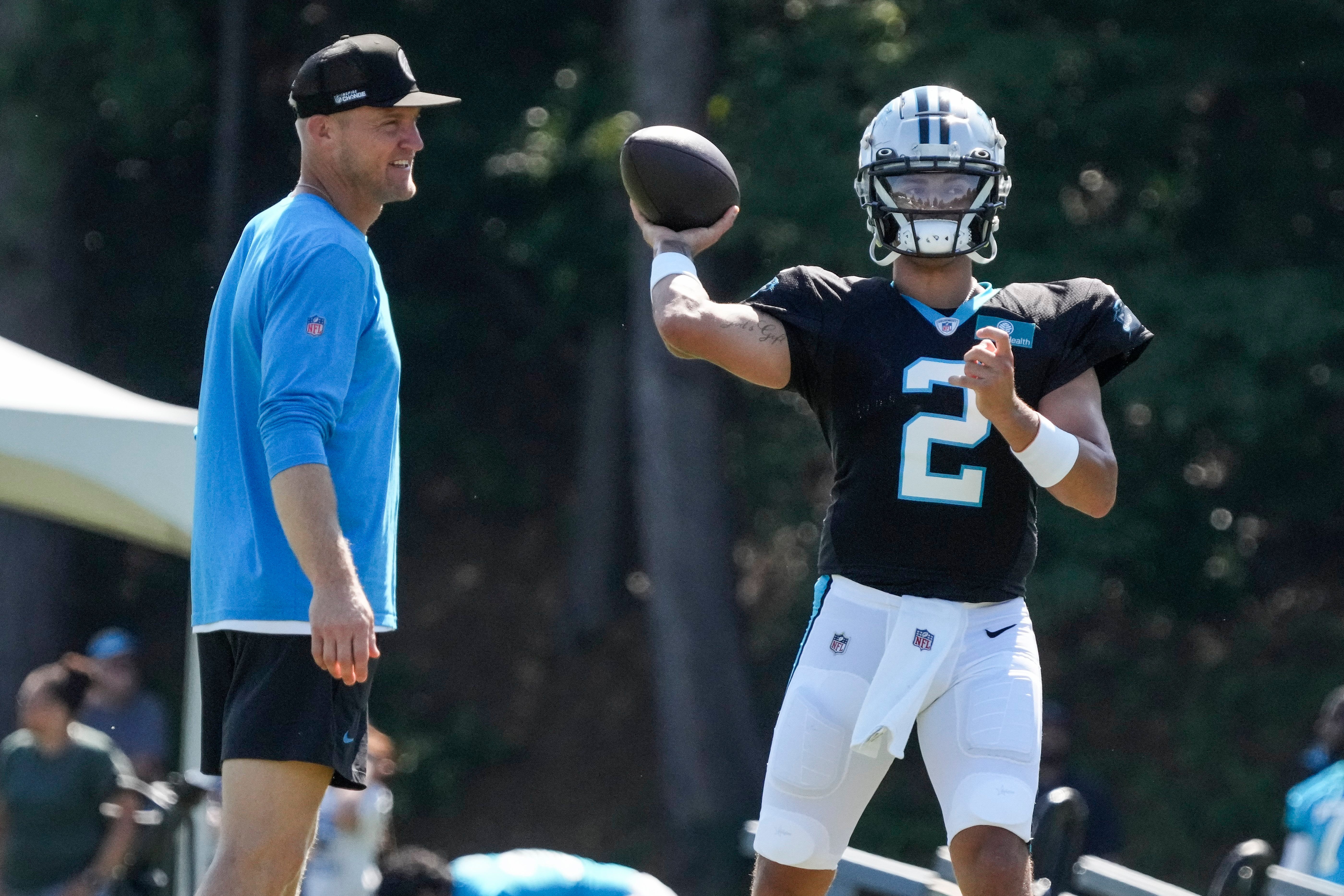 Jul 31, 2023; Spartanburg, SC, USA; Carolina Panthers quarterback Bryce Young (9) throws with coach Josh MacCown watching during training camp at Wofford.