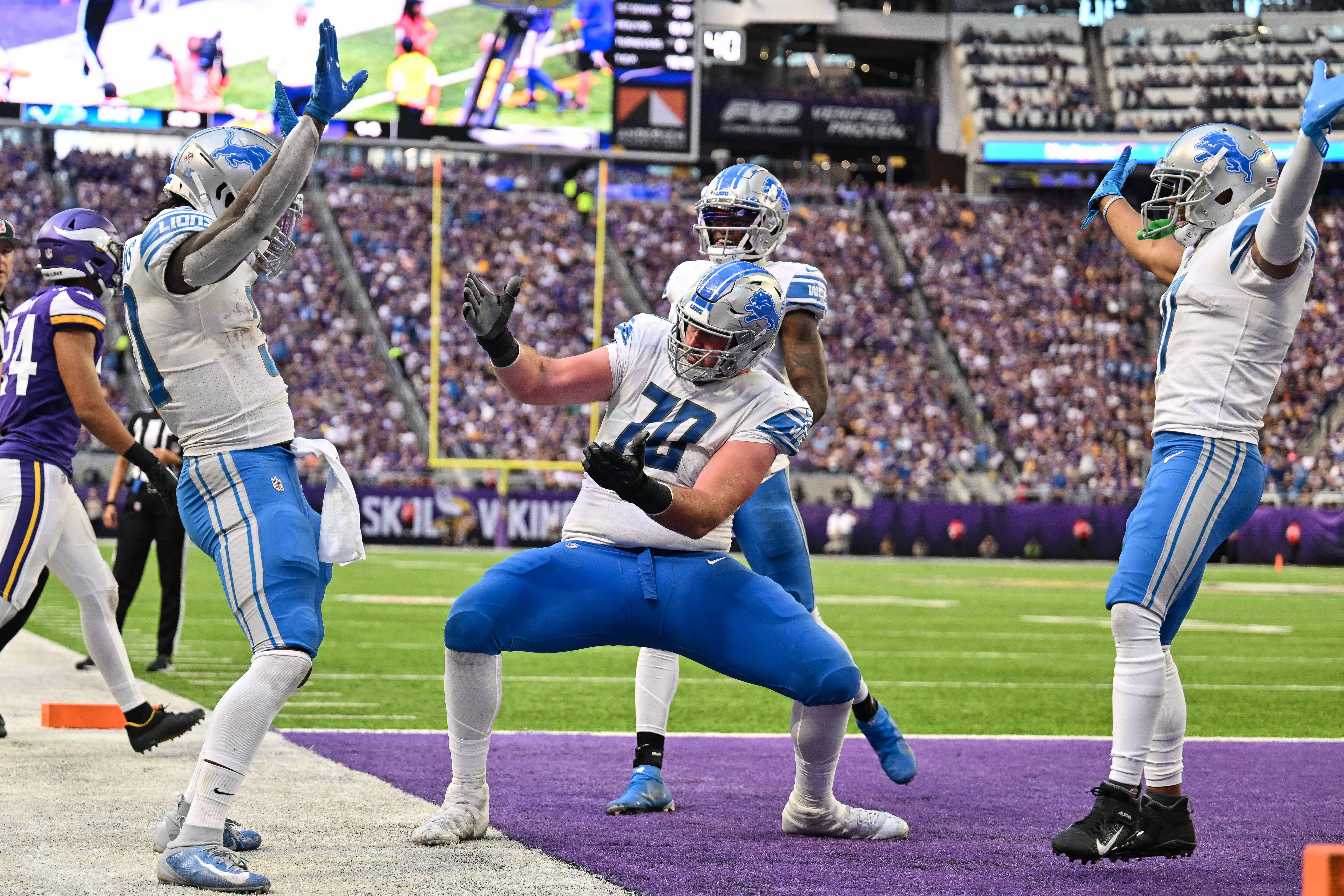 Sep 25, 2022; Minneapolis, Minnesota, USA; Detroit Lions running back Jamaal Williams (left) and offensive tackle Dan Skipper (70) and wide receiver DJ Chark (4) and wide receiver Kalif Raymond (right) react after a touchdown by Williams against the Minnesota Vikings during the second quarter at U.S. Bank Stadium.