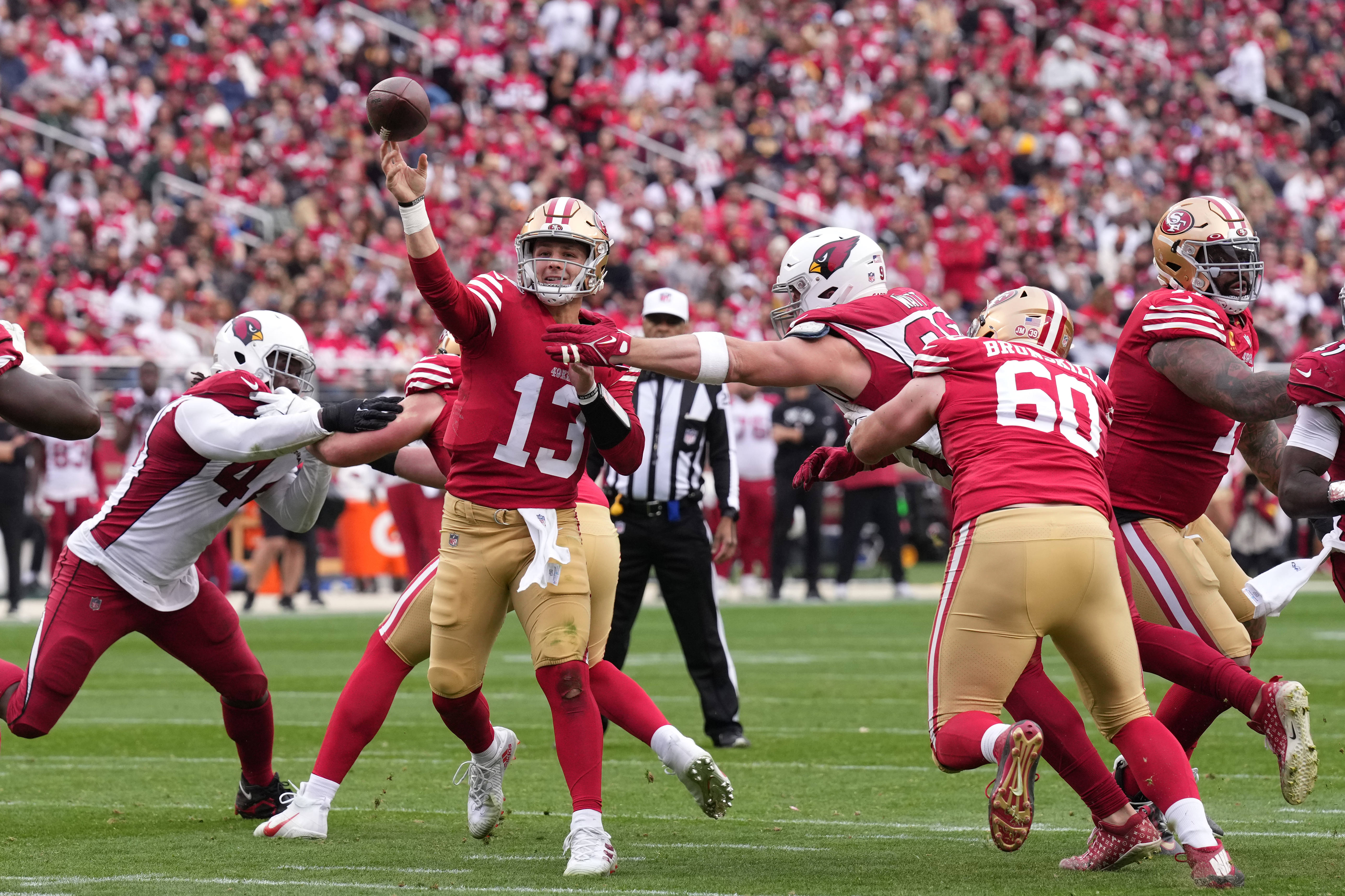 Jan 8, 2023; Santa Clara, California, USA; San Francisco 49ers quarterback Brock Purdy (13) throws a touchdown pass against Arizona Cardinals defensive end J.J. Watt (99) during the second quarter at Levi's Stadium. Mandatory Credit: Darren Yamashita-USA TODAY Sports