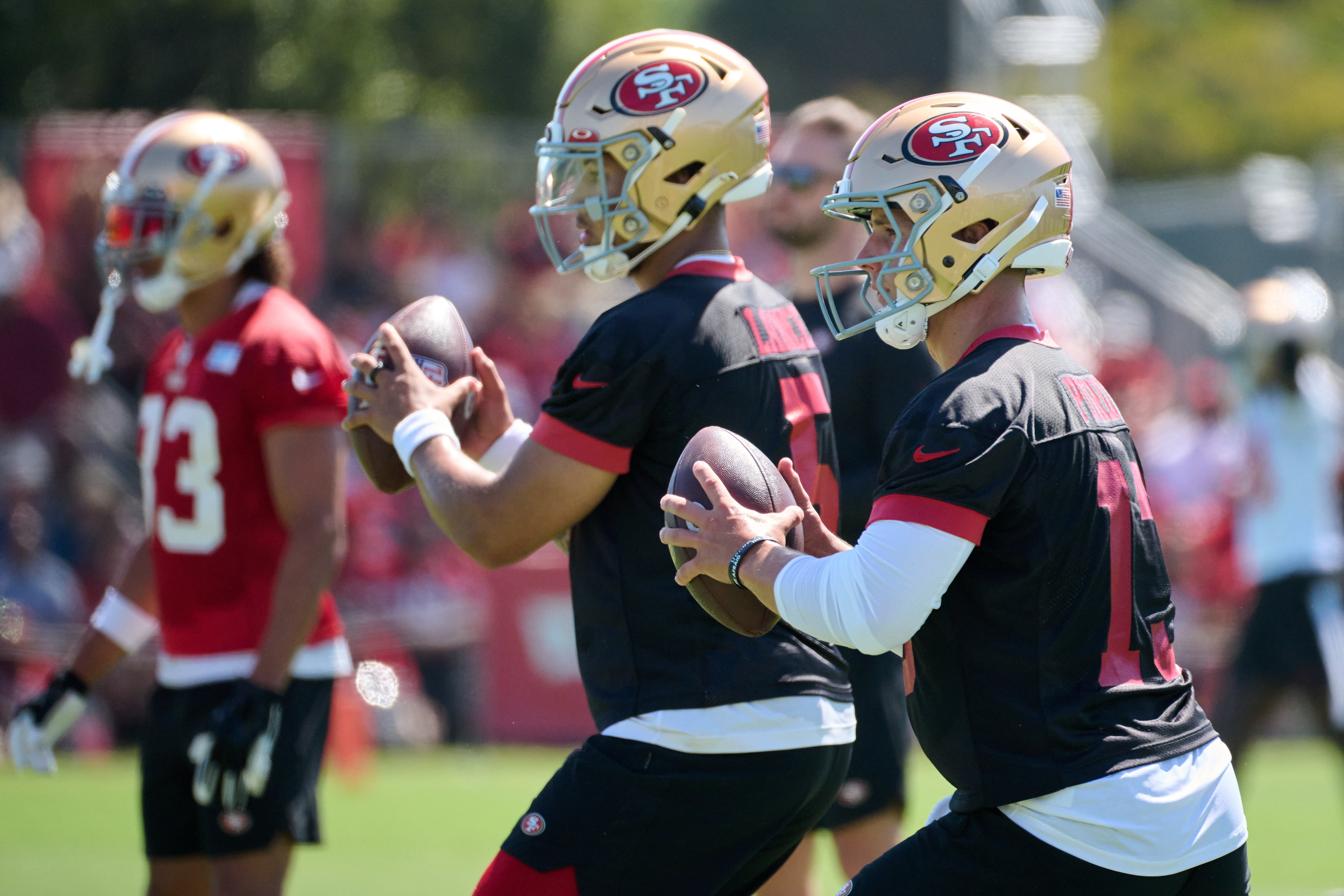 Jul 27, 2023; Santa Clara, CA, USA; San Francisco 49ers quarterback Brock Purdy (13) and quarterback Trey Lance (5) drop back to throw a pass during training camp at the SAP Performance Facility. Mandatory Credit: Robert Edwards-USA TODAY Sports
