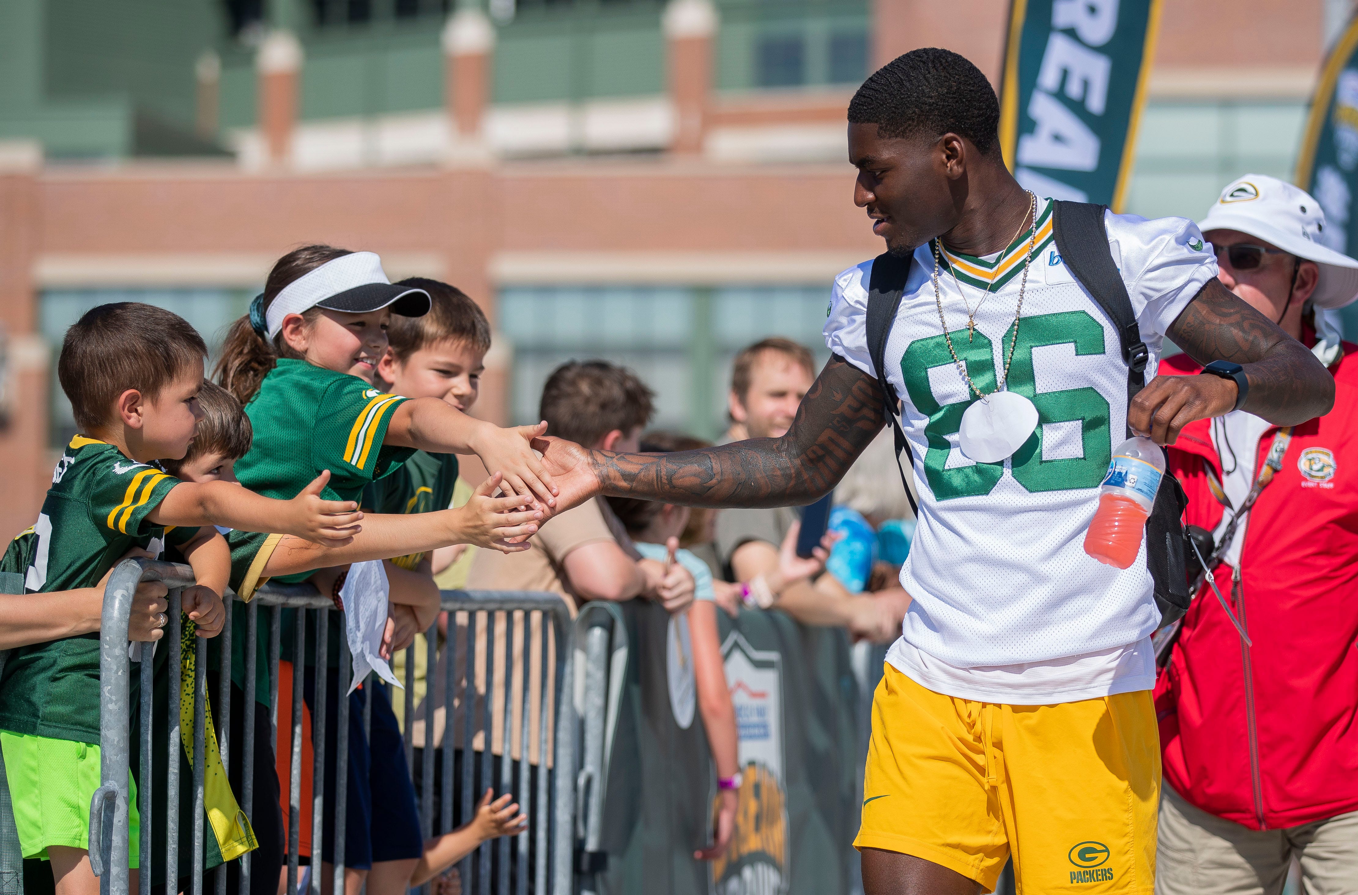 Green Bay Packers wide receiver Grant DuBose (86) slaps hands with young fans as he walks to practice on Thursday, August 3, 2023, at Lambeau Field in Green Bay, Wis.