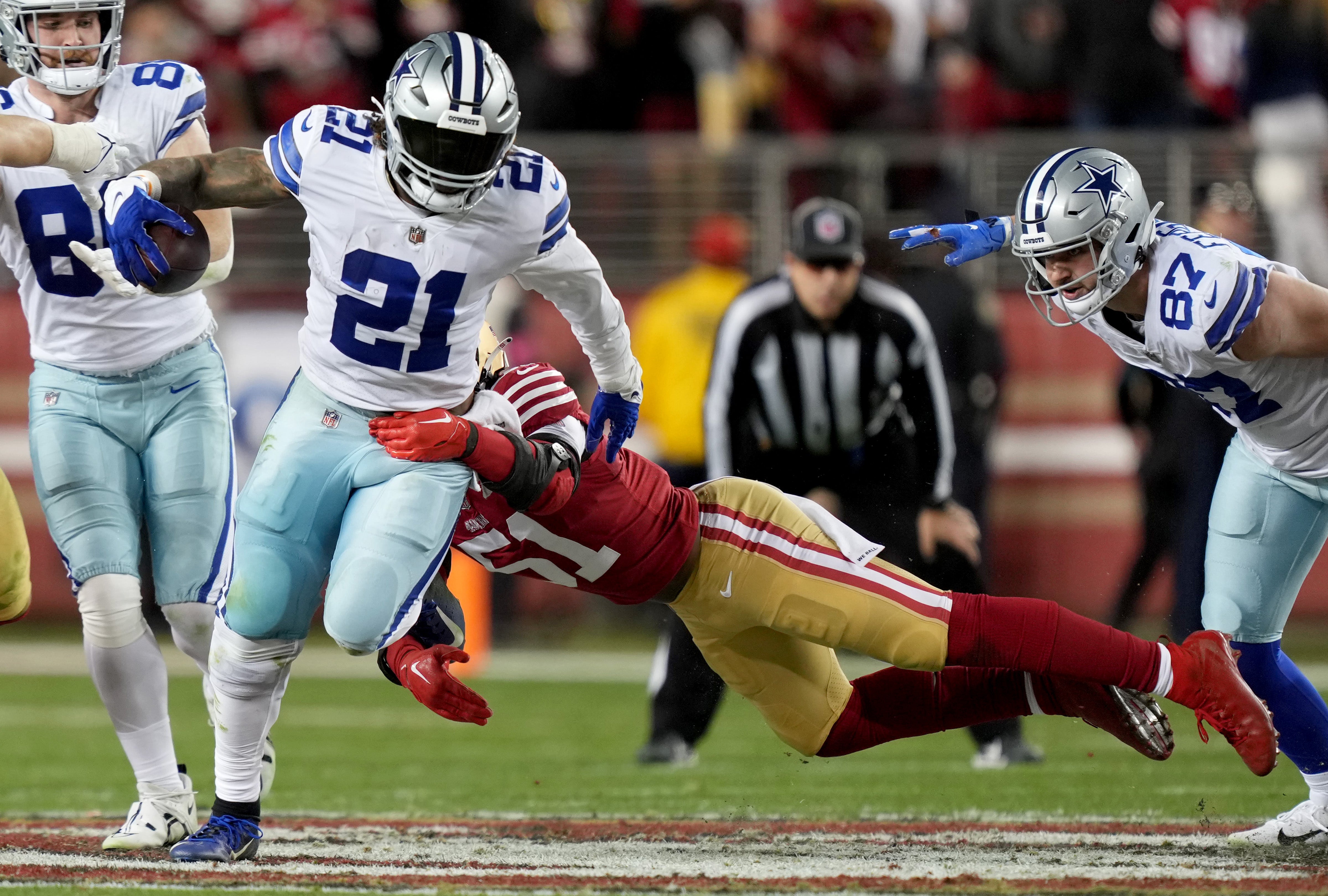 Dallas Cowboys running back Ezekiel Elliott (21) runs past San Francisco 49ers linebacker Azeez Al-Shaair (51) during the fourth quarter of a NFC divisional round game at Levi's Stadium.