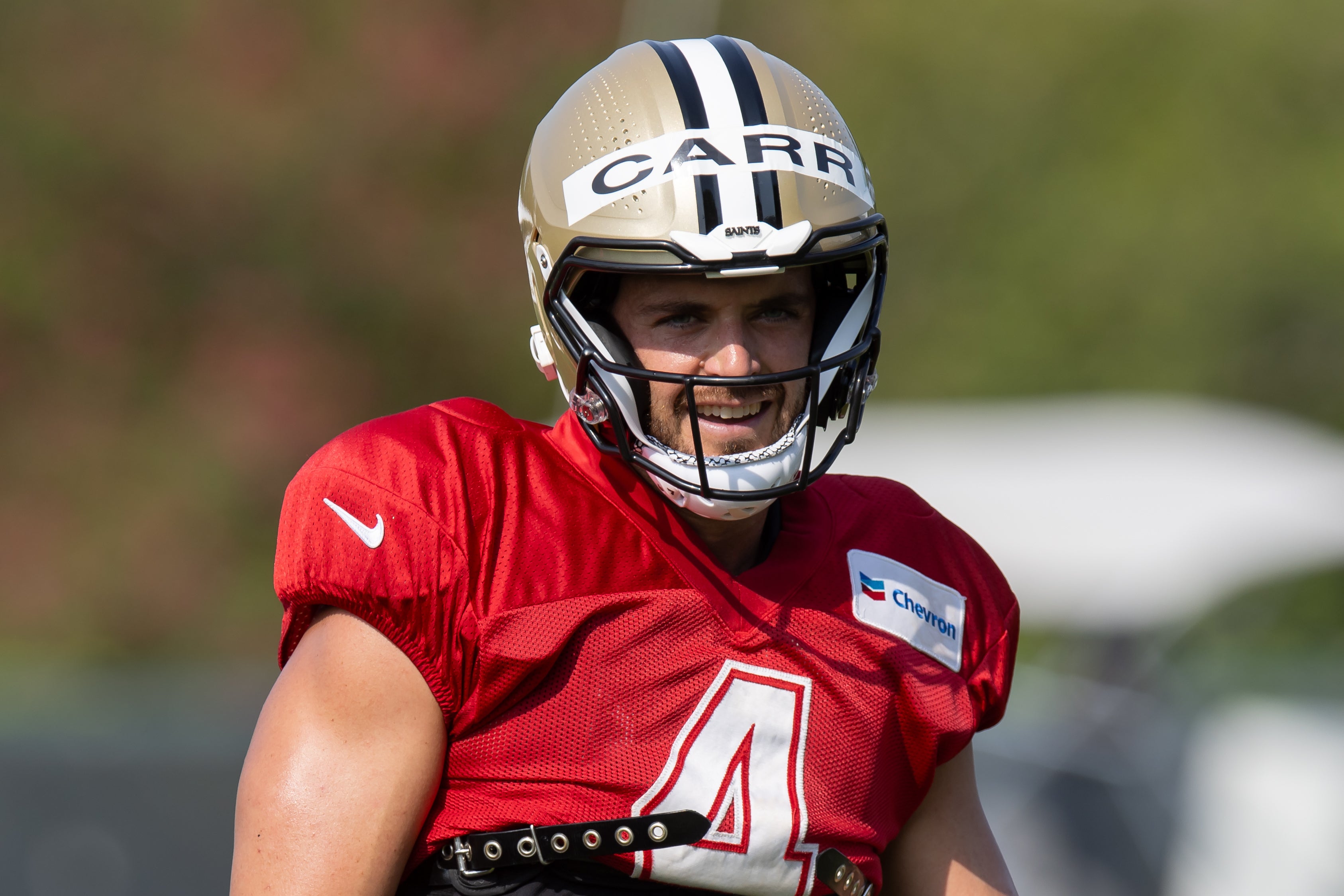 Jul 31, 2023; Metairie, LA, USA; New Orleans Saints quarterback Derek Carr (4) smiles for the fans during training camp at the Ochsner Sports Performance Center. Mandatory Credit: Stephen Lew-USA TODAY Sports