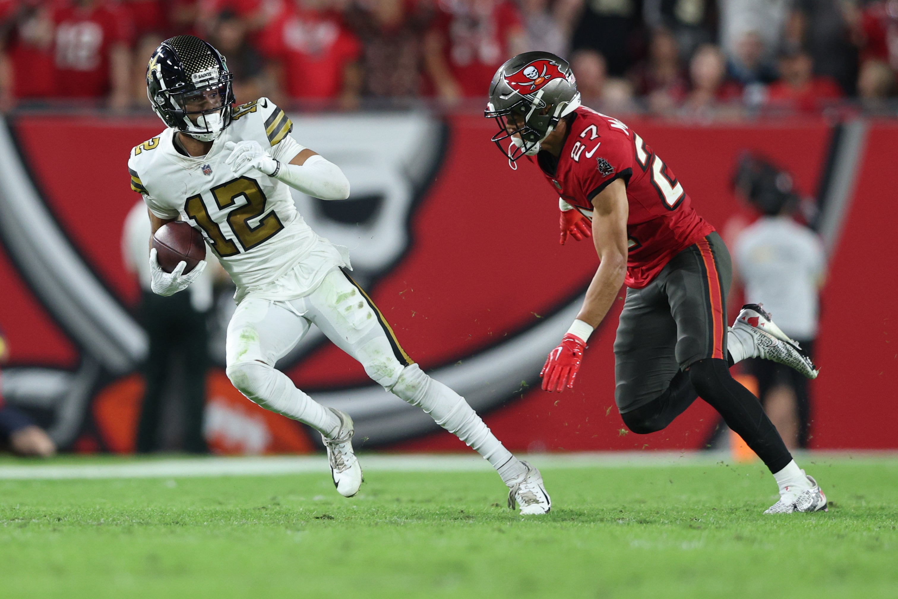 Dec 5, 2022; Tampa, Florida, USA; New Orleans Saints wide receiver Chris Olave (12) is chased by Tampa Bay Buccaneers cornerback Zyon McCollum (27) in the fourth quarter at Raymond James Stadium. Mandatory Credit: Nathan Ray Seebeck-USA TODAY Sports