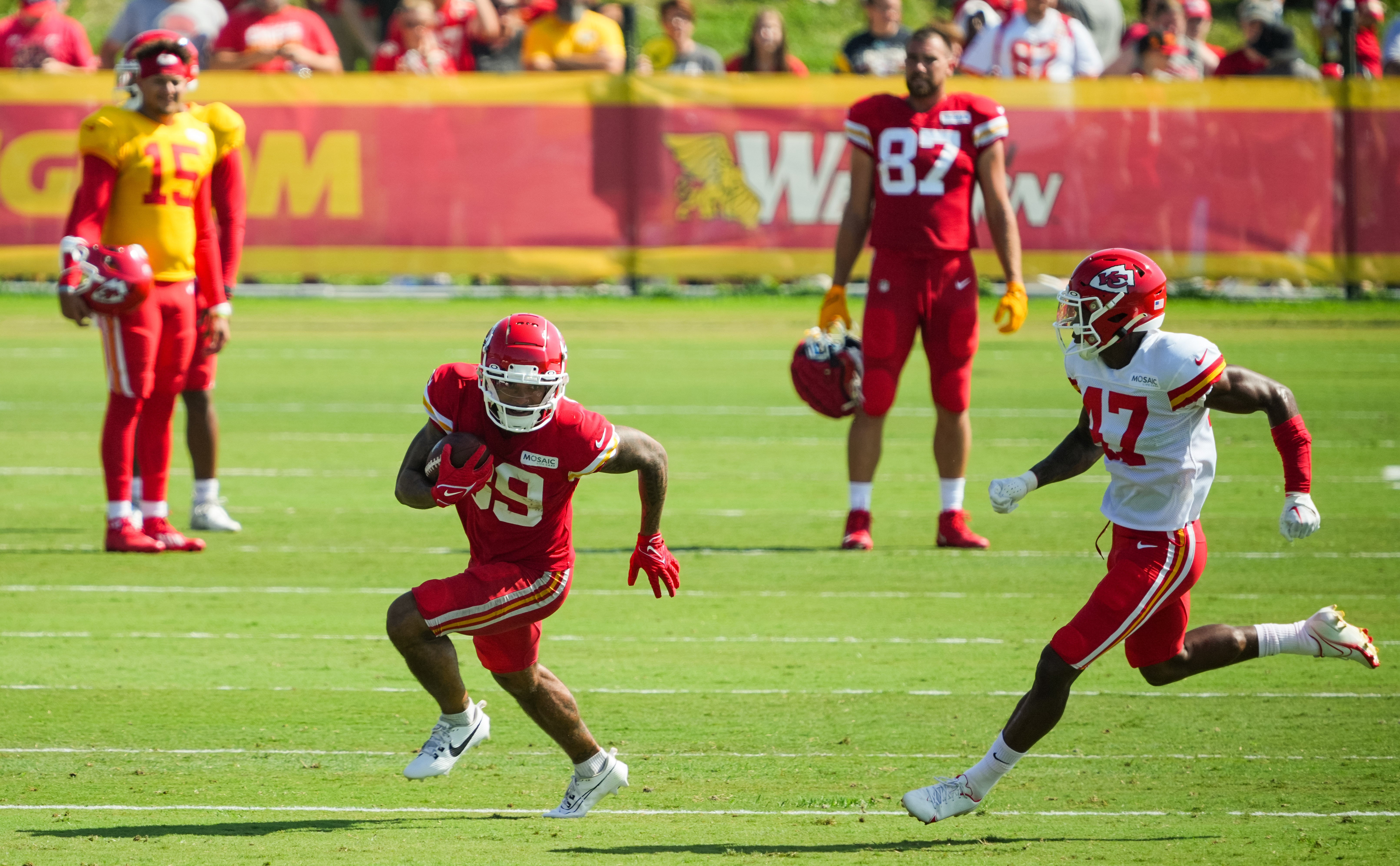 Jul 28, 2023; St. Joseph, MO, USA; Kansas City Chiefs wide receiver Kekoa Crawford (89) runs the ball against safety Anthony Cook (47) as quarterback Patrick Mahomes (15) and tight end Travis Kelce (87) look on during training camp at Missouri Western State University. Mandatory Credit: Jay Biggerstaff-USA TODAY Sports