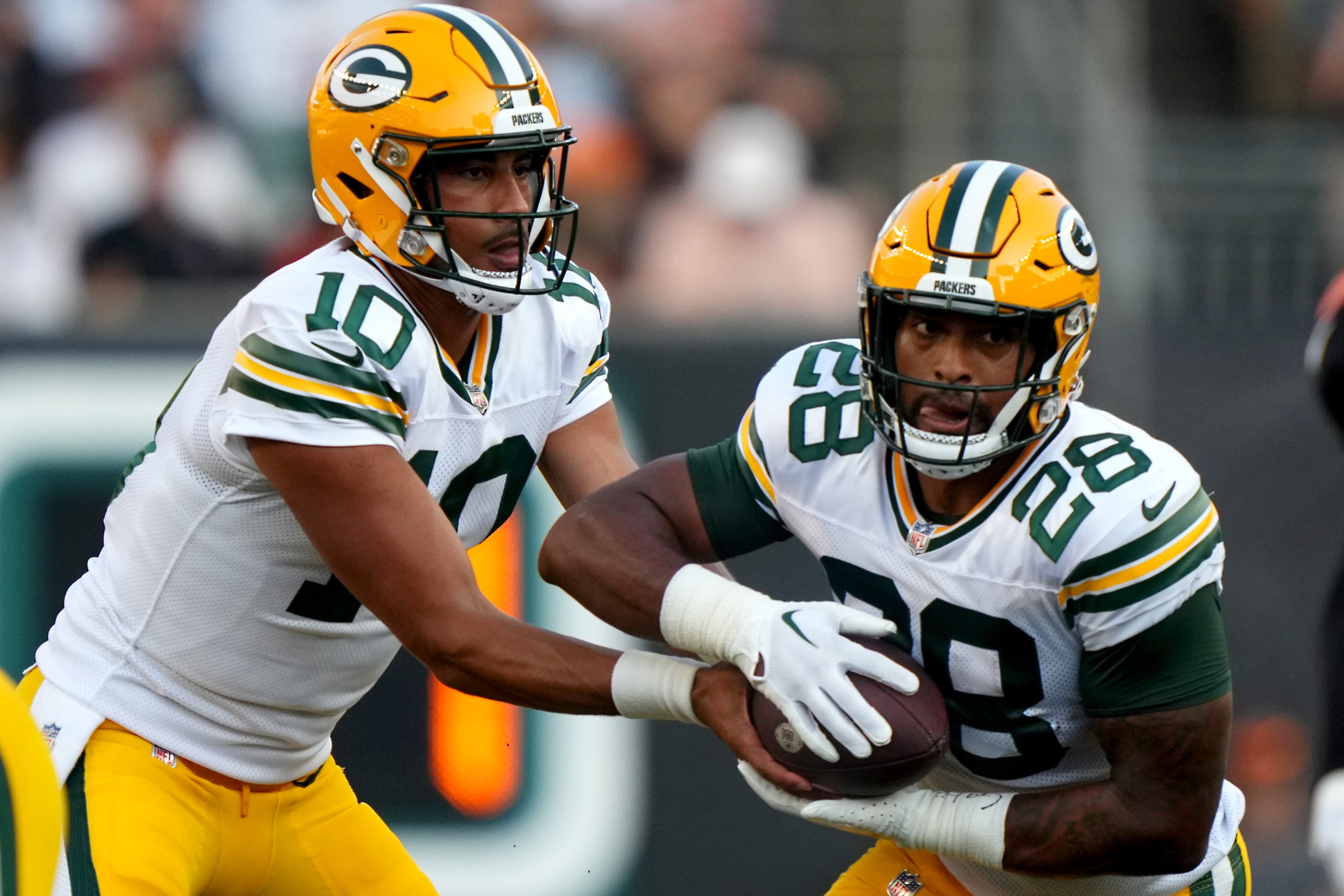 Green Bay Packers quarterback Jordan Love (10) hands the ball off to Green Bay Packers running back AJ Dillon (28) in the first quarter during a Week 1 NFL preseason game between the Green Bay Packers and the Cincinnati Bengals,Friday, Aug. 11, 2023, at Paycor Stadium in Cincinnati. Kareem Elgazzar/The Enquirer / USA TODAY NETWORK