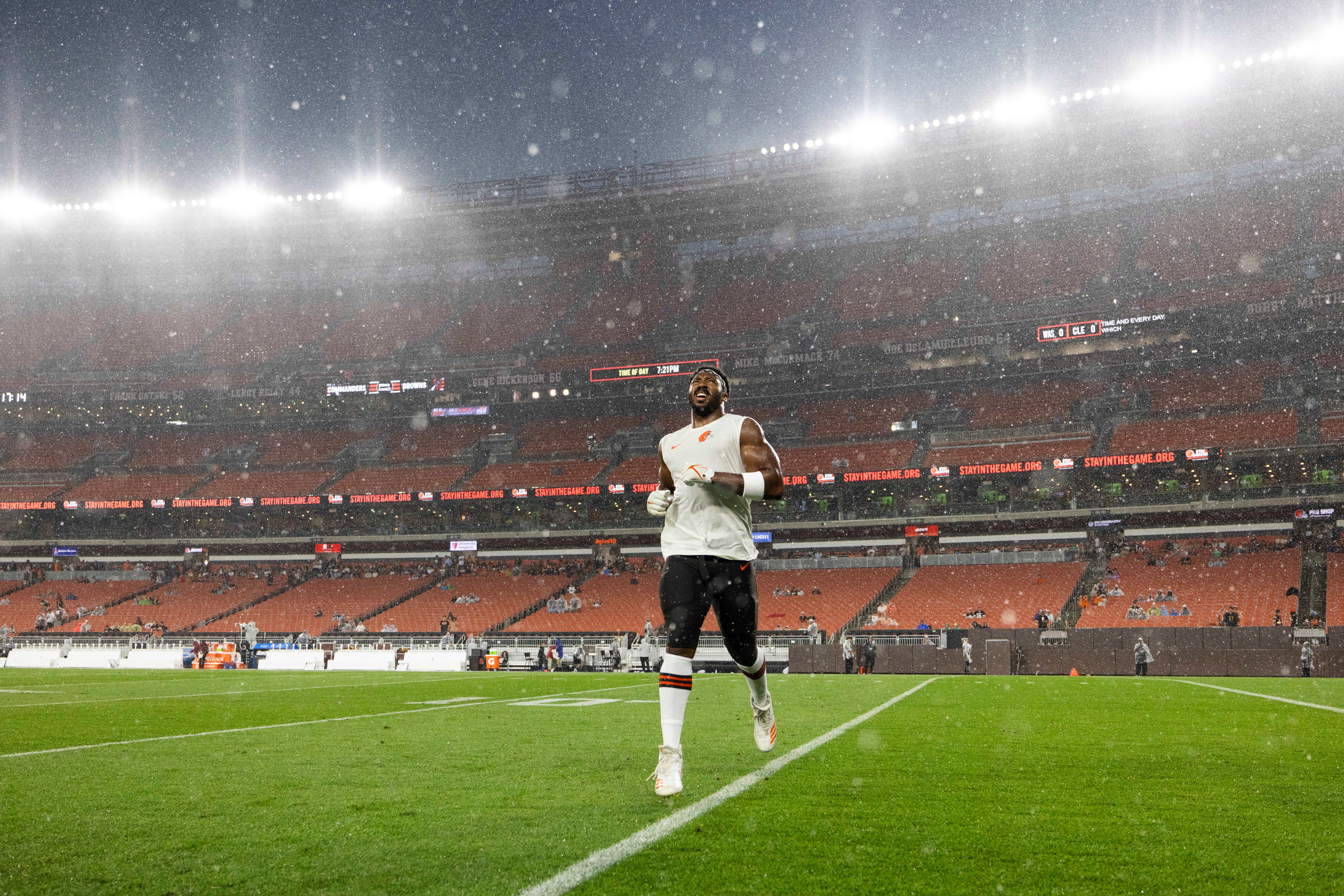Aug 11, 2023; Cleveland, Ohio, USA; Cleveland Browns defensive end Myles Garrett (95) runs in the rain before the game against the Washington Commanders which was delayed due to severe weather at Cleveland Browns Stadium. Mandatory Credit: Scott Galvin-USA TODAY Sports