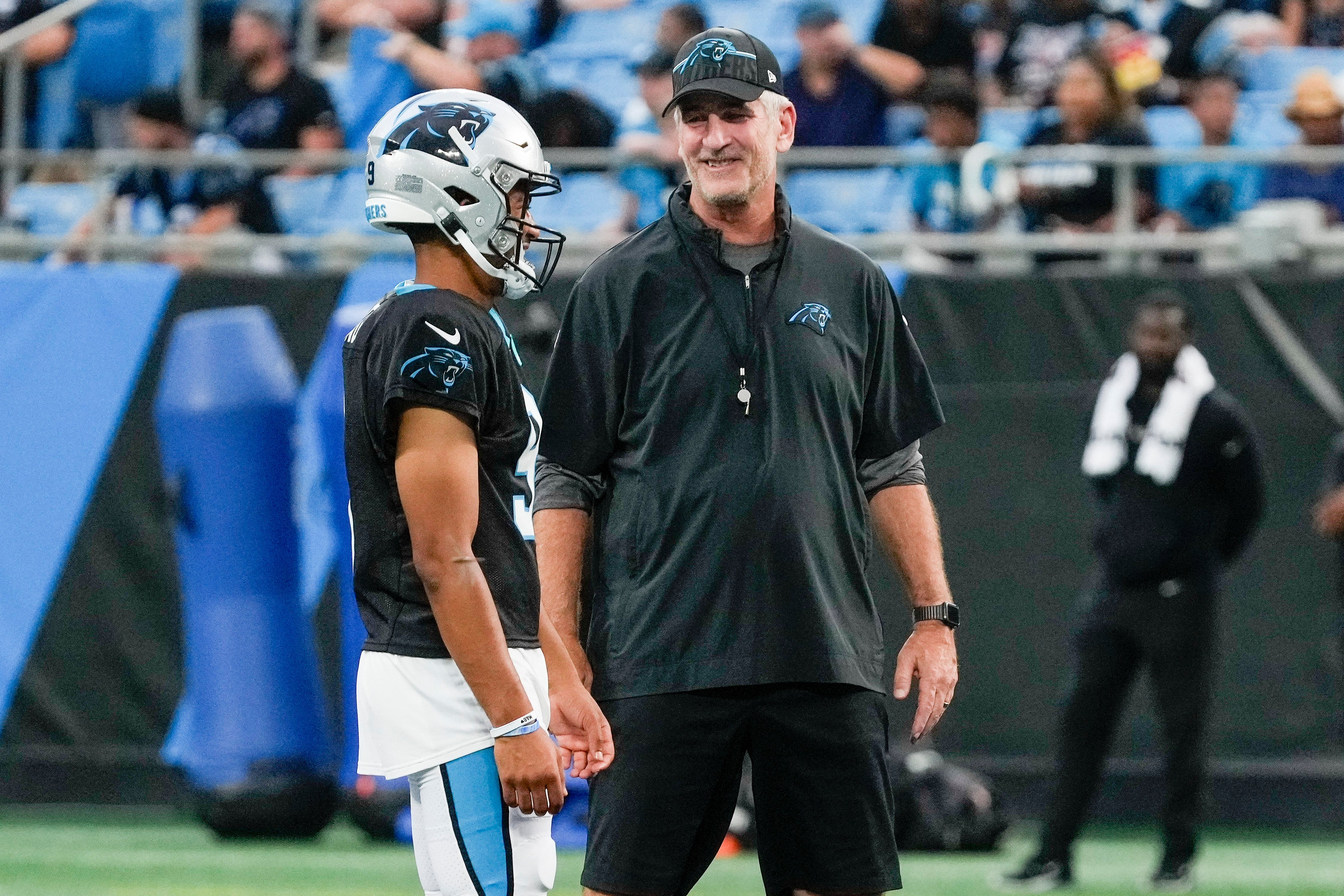 Aug 2, 2023; Charlotte, NC, USA; Carolina Panthers head coach Frank Reich talks at midfield with quarterback Bryce Young (9) during Fan Fest at Bank of America Stadium in Charlotte, NC. Mandatory Credit: Jim Dedmon-USA TODAY Sports