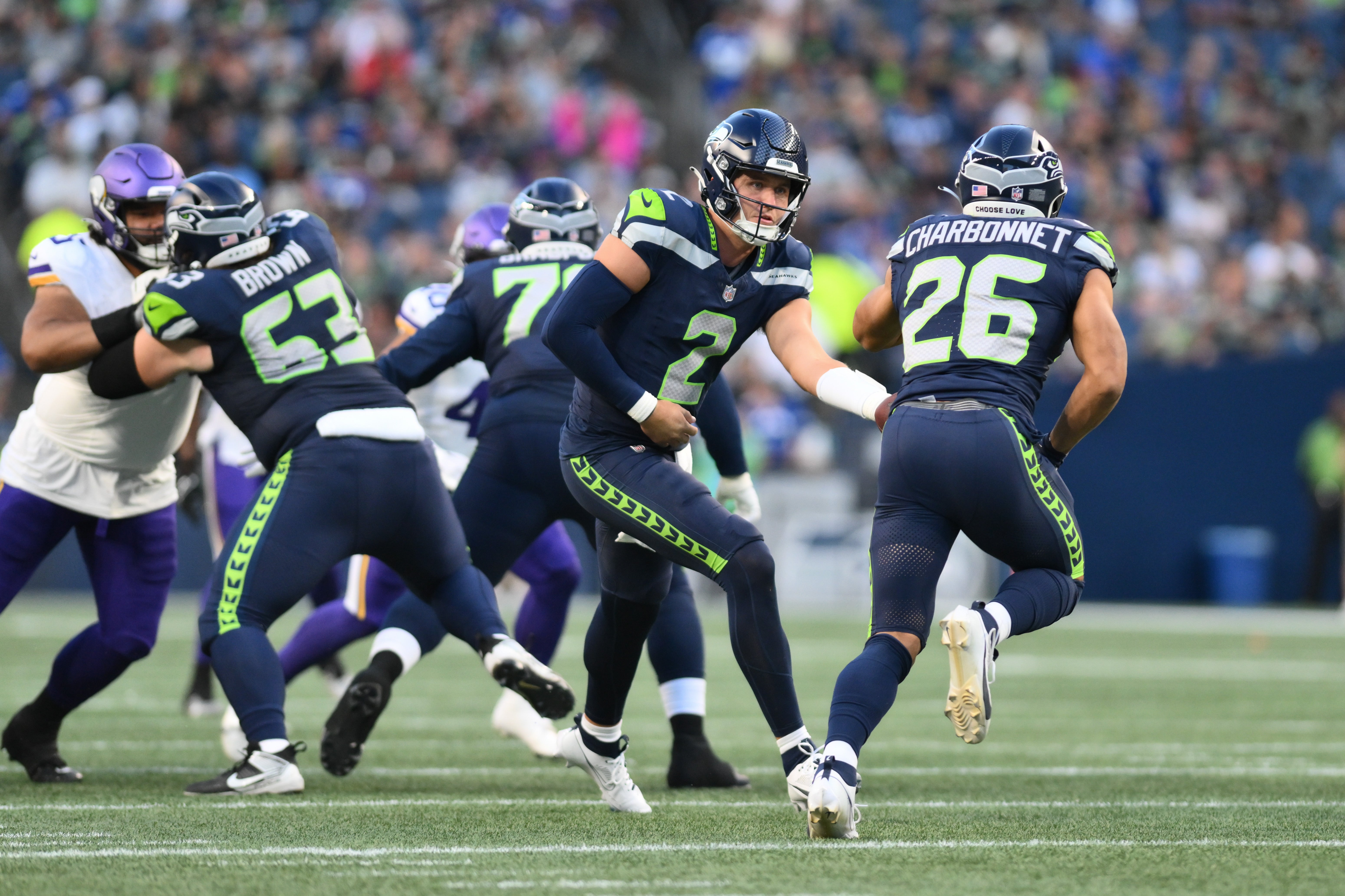 Aug 10, 2023; Seattle, Washington, USA; Seattle Seahawks quarterback Drew Lock (2) hands the ball off to running back Zach Charbonnet (26) during the first half at Lumen Field. Mandatory Credit: Steven Bisig-USA TODAY Sports