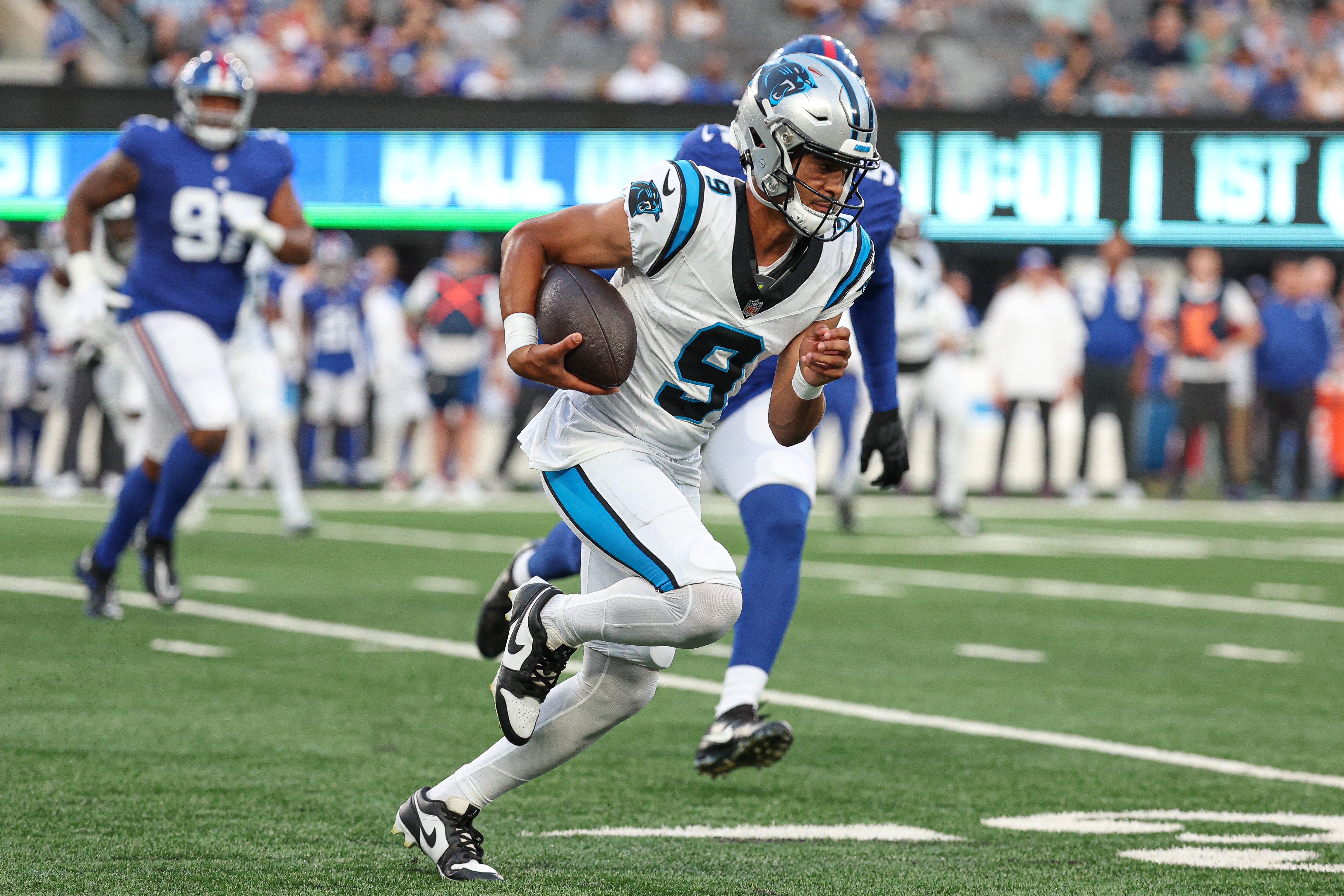 Aug 18, 2023; East Rutherford, New Jersey, USA; Carolina Panthers quarterback Bryce Young (9) scrambles in front of New York Giants linebacker Azeez Ojulari (51) during the first quarter at MetLife Stadium. Mandatory Credit: Vincent Carchietta-USA TODAY Sports