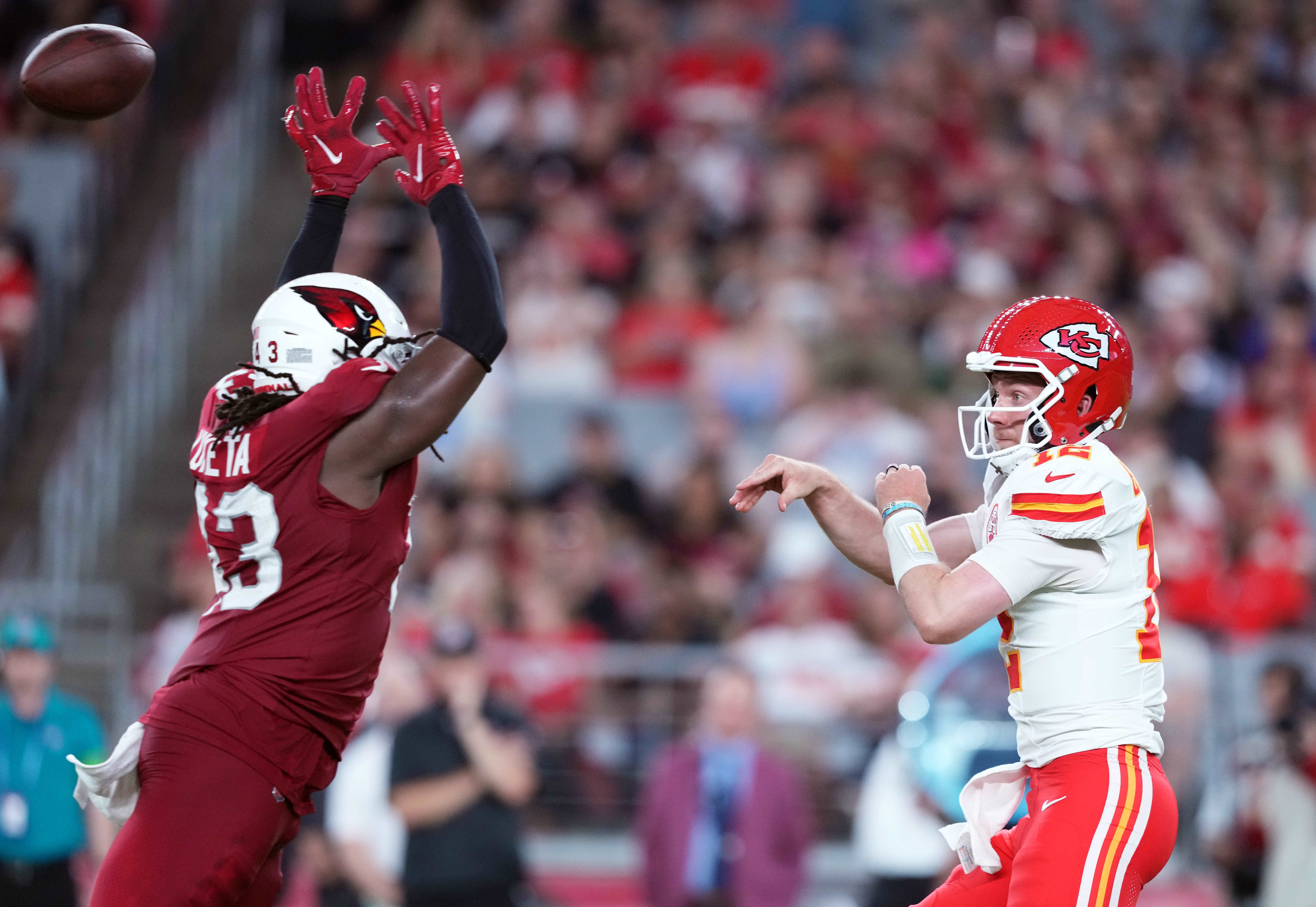 Aug 19, 2023; Glendale, Arizona, USA; Kansas City Chiefs quarterback Shane Buechele (12) throws the ball by Arizona Cardinals linebacker Jesse Luketa (43) during the first half at State Farm Stadium. Mandatory Credit: Joe Camporeale-USA TODAY Sports