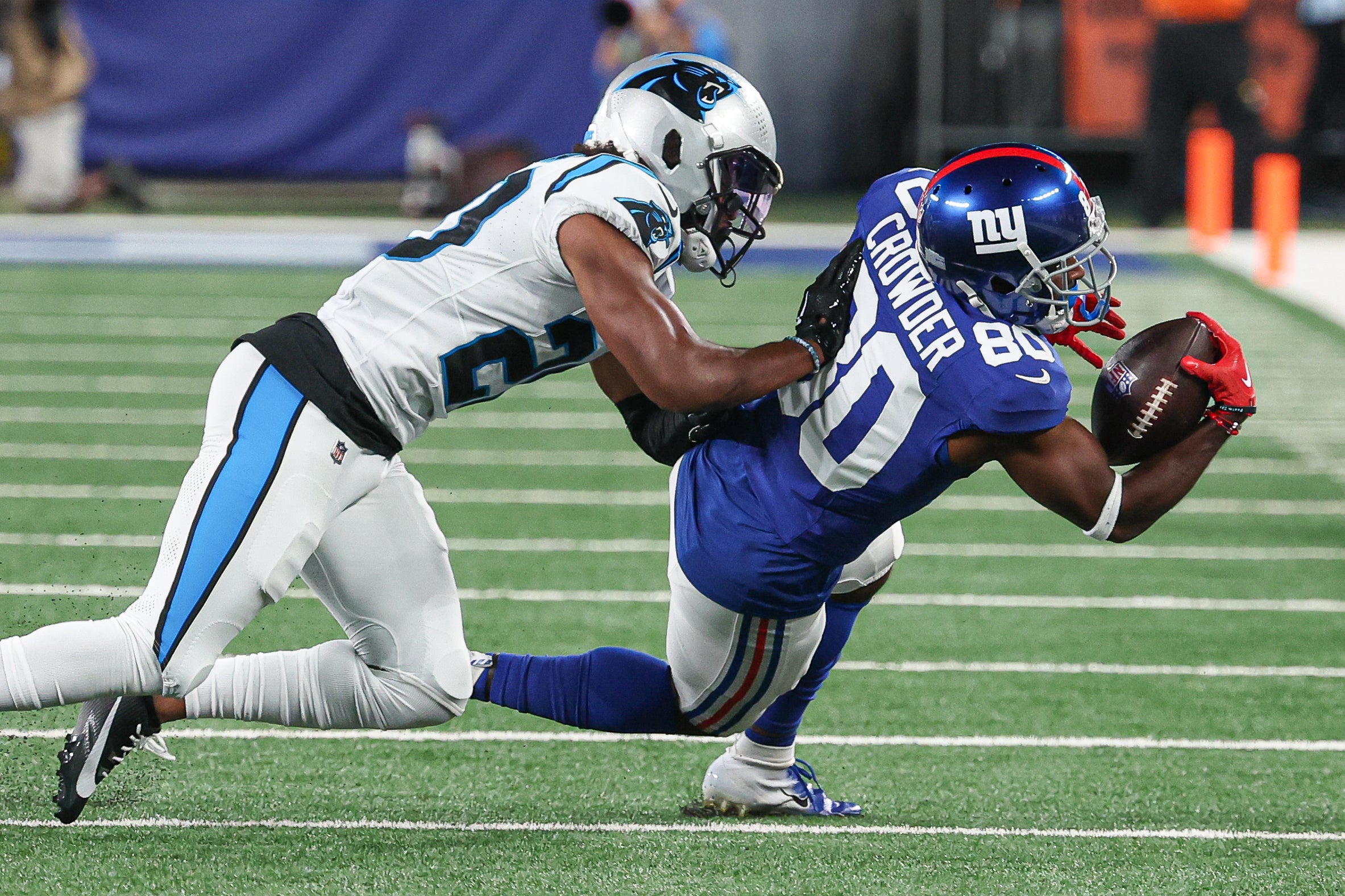 Aug 18, 2023; East Rutherford, New Jersey, USA; New York Giants wide receiver Jamison Crowder (80) is tackled by Carolina Panthers cornerback Eric Rowe (20) during the second half at MetLife Stadium. Mandatory Credit: Vincent Carchietta-USA TODAY Sports