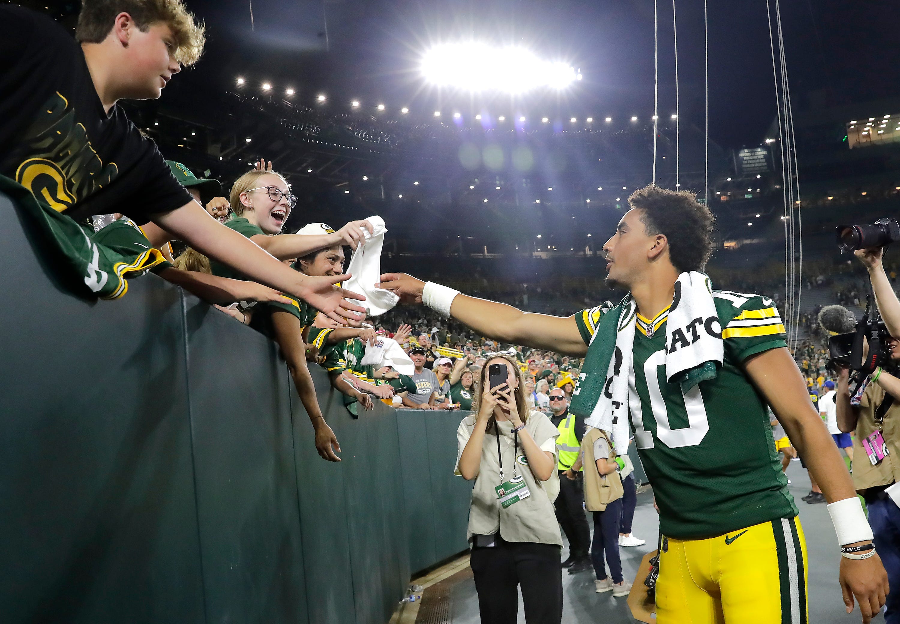 Green Bay Packers quarterback Jordan Love (10) passes a towel to a youg fan following the Packers during their preseason football game against the New England Patriots on Saturday, August 19, 2023, at Lambeau Field in Green Bay, Wis. The game was suspended in the fourth quarter following an injury to New England Patriots cornerback Isaiah Bolden (7). Wm. Glasheen USA TODAY NETWORK-Wisconsin