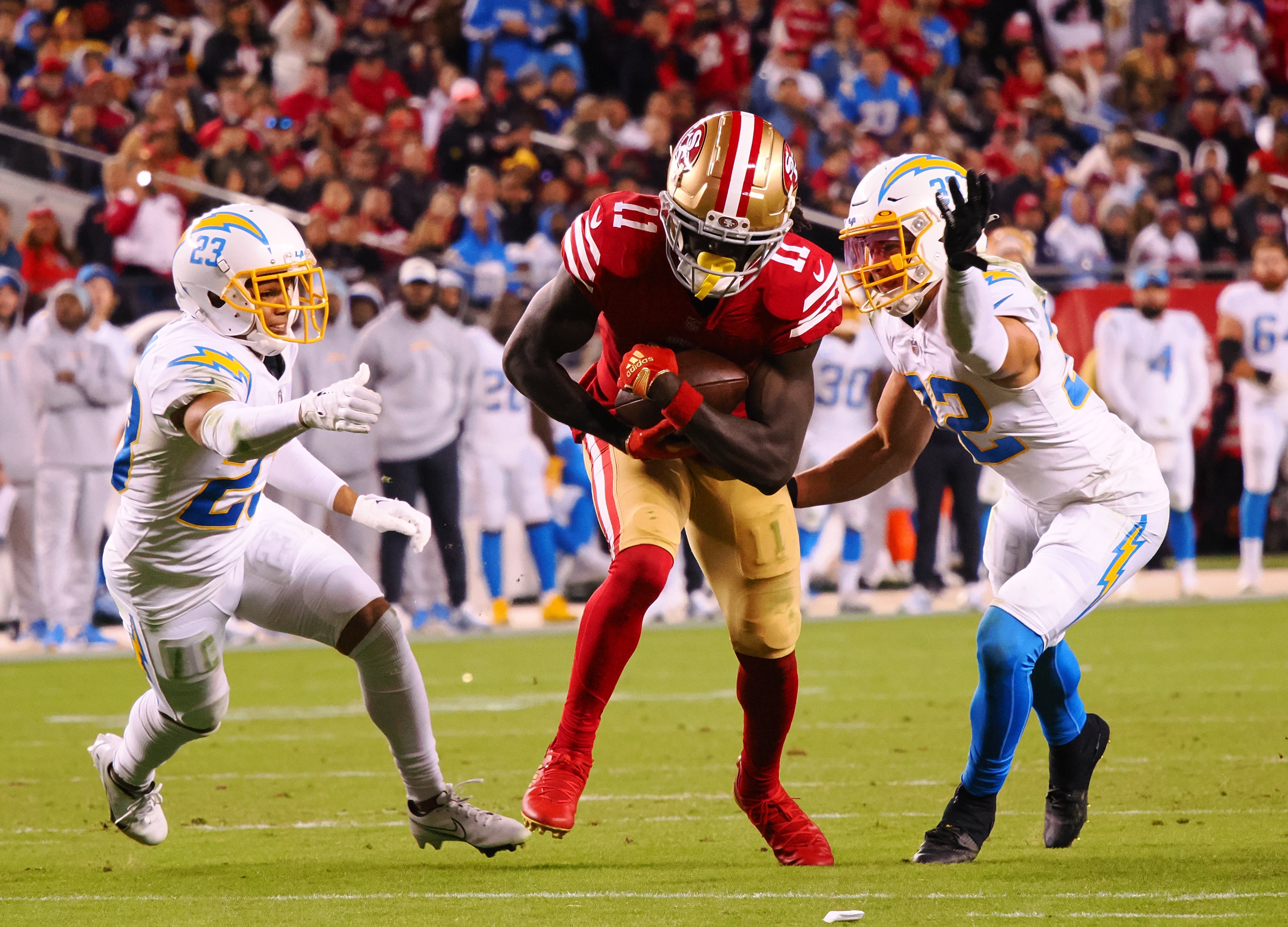 Nov 13, 2022; Santa Clara, California, USA; San Francisco 49ers wide receiver Brandon Aiyuk (11) carries the ball against Los Angeles Chargers cornerback Bryce Callahan (23) and safety Alohi Gilman (32) during the fourth quarter at Levi's Stadium. Mandatory Credit: Kelley L Cox-USA TODAY Sports