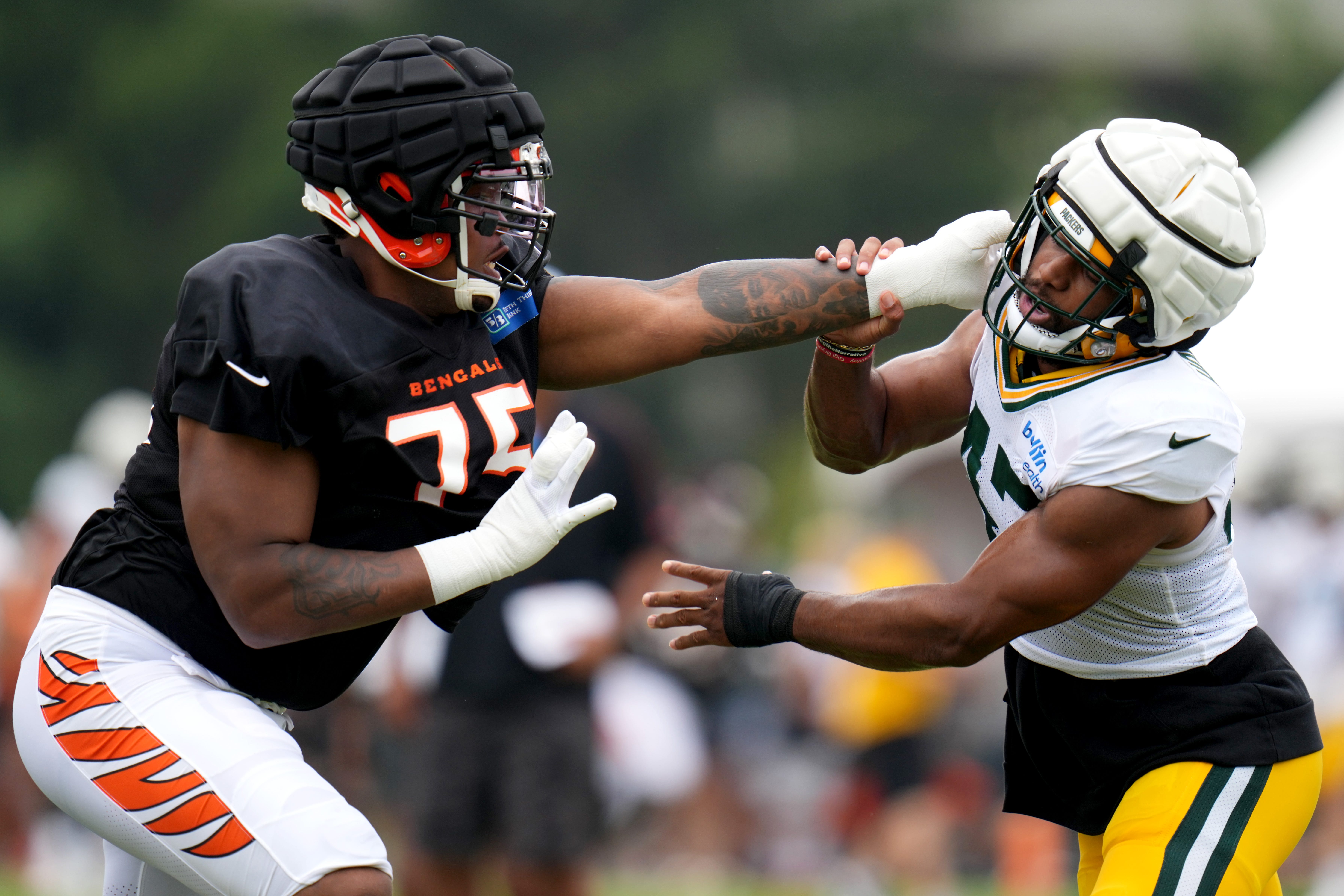 Cincinnati Bengals offensive tackle Orlando Brown Jr. (75), left, and Green Bay Packers linebacker Justin Hollins (47) compete during a joint practice between the Green Bay Packers and the Cincinnati Bengals, Wednesday, Aug. 9, 2023, at the practice fields next to Paycor Stadium in Cincinnati.