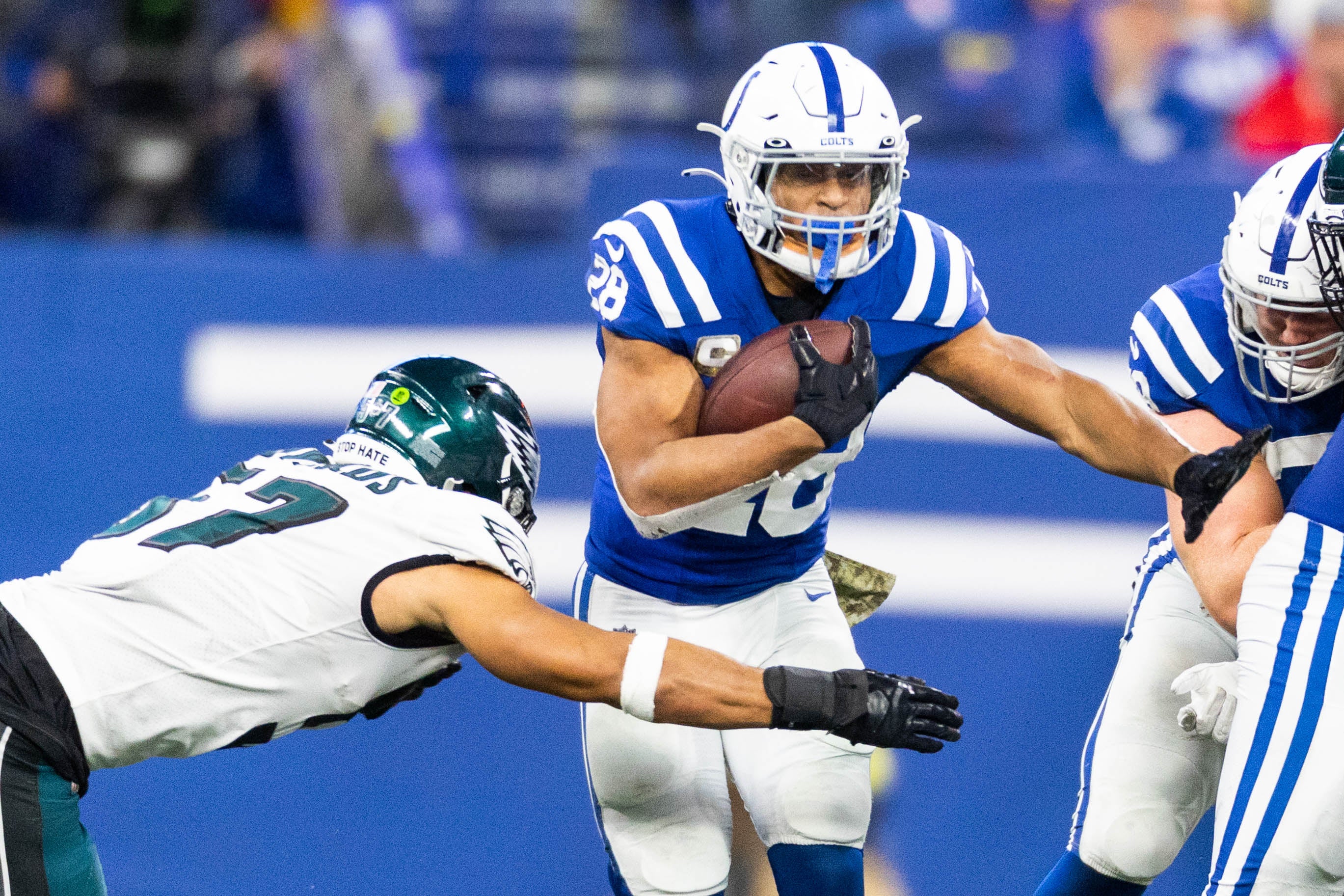 Nov 20, 2022; Indianapolis, Indiana, USA; Indianapolis Colts running back Jonathan Taylor (28) runs the ball while Philadelphia Eagles linebacker T.J. Edwards (57) defends in the second half at Lucas Oil Stadium.