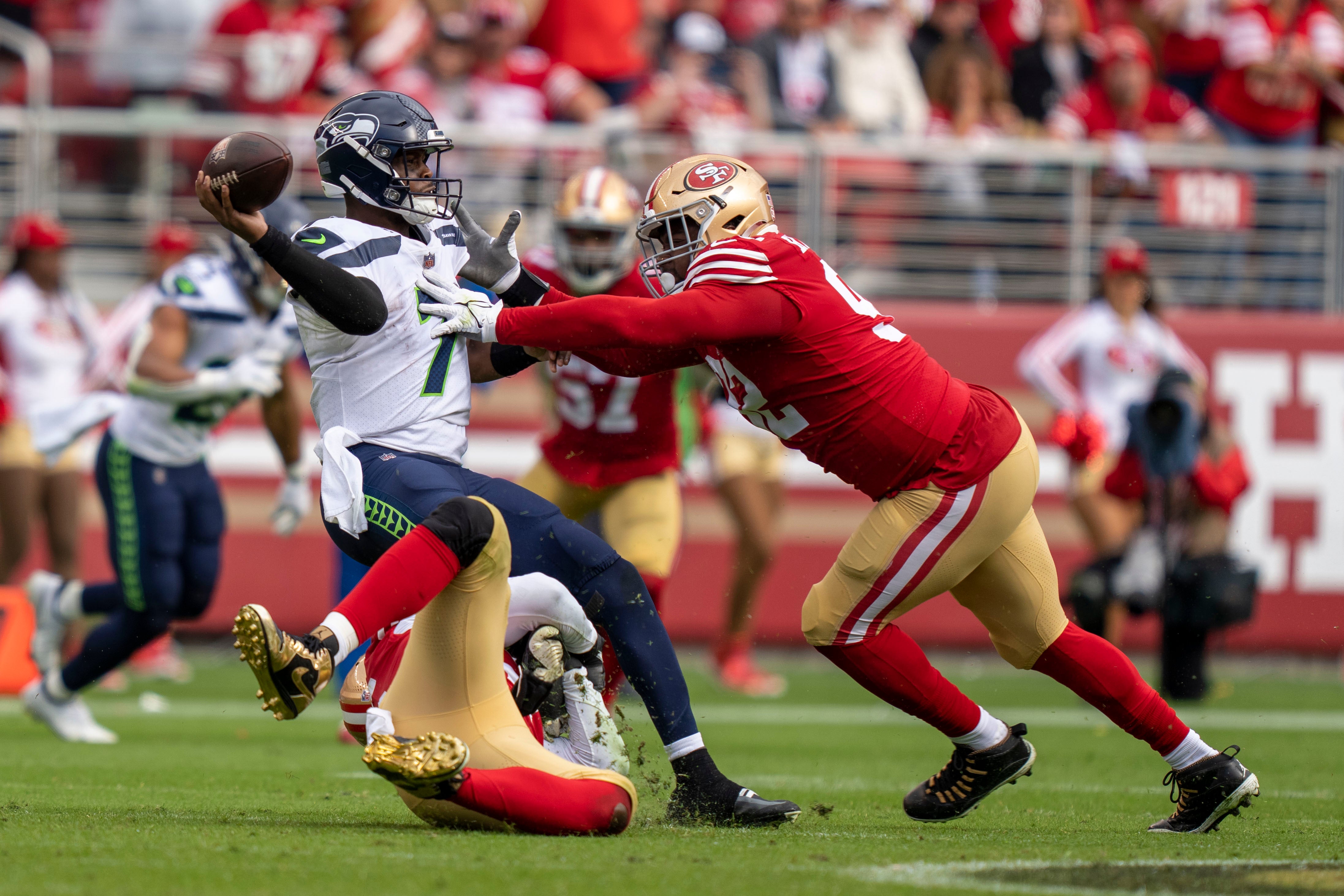 September 18, 2022; Santa Clara, California, USA; Seattle Seahawks quarterback Geno Smith (7) throws the football for intentional grounding against San Francisco 49ers defensive end Samson Ebukam (56, bottom) and defensive end Kerry Hyder Jr. (92, right) during the fourth quarter at Levi's Stadium. Mandatory Credit: Kyle Terada-USA TODAY Sports
