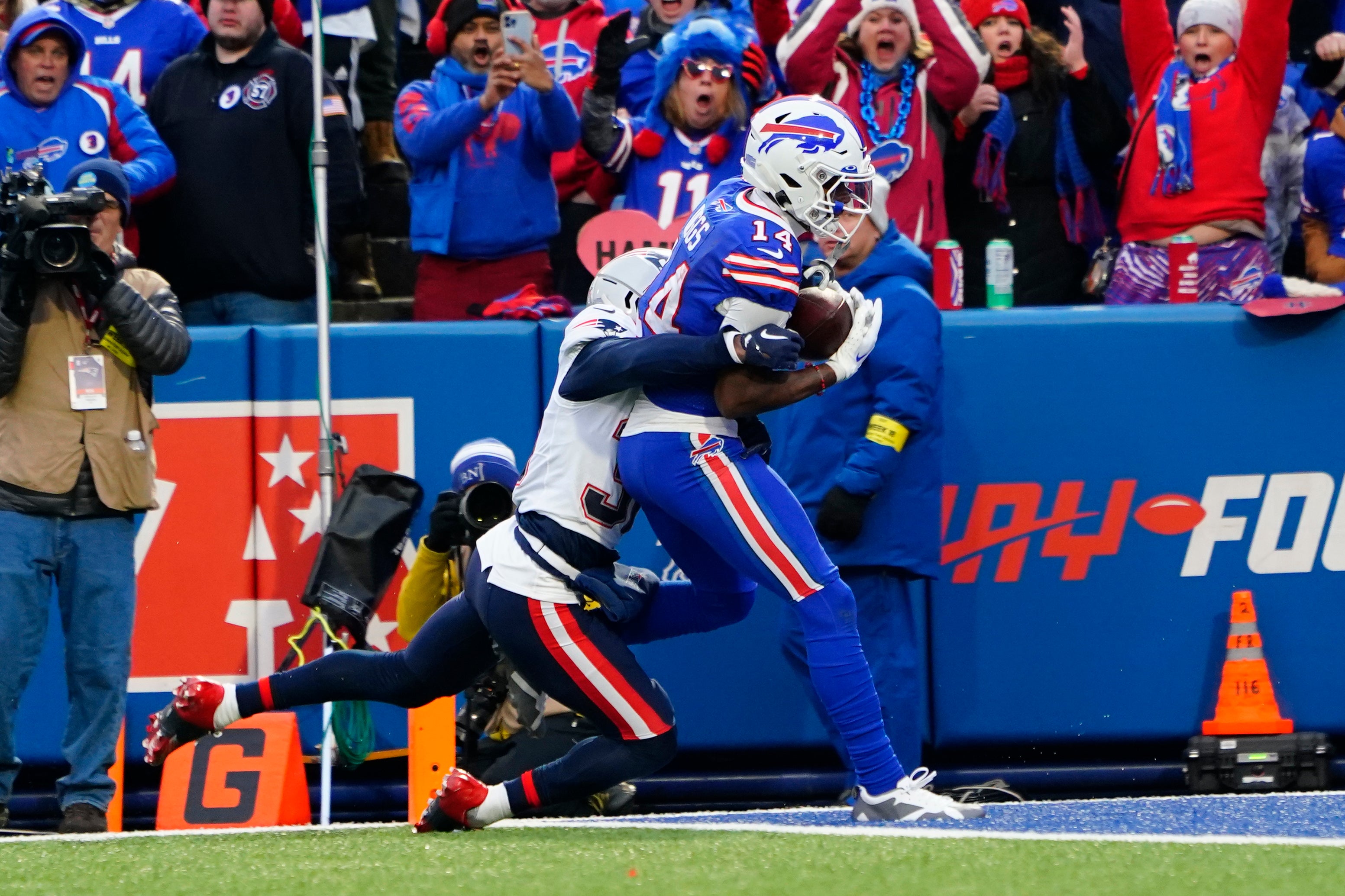 Jan 8, 2023; Orchard Park, New York, USA; Buffalo Bills wide receiver Stefon Diggs (14) scores a touchdown after making a catch against New England Patriots cornerback Jonathan Jones (31) during the second half at Highmark Stadium.