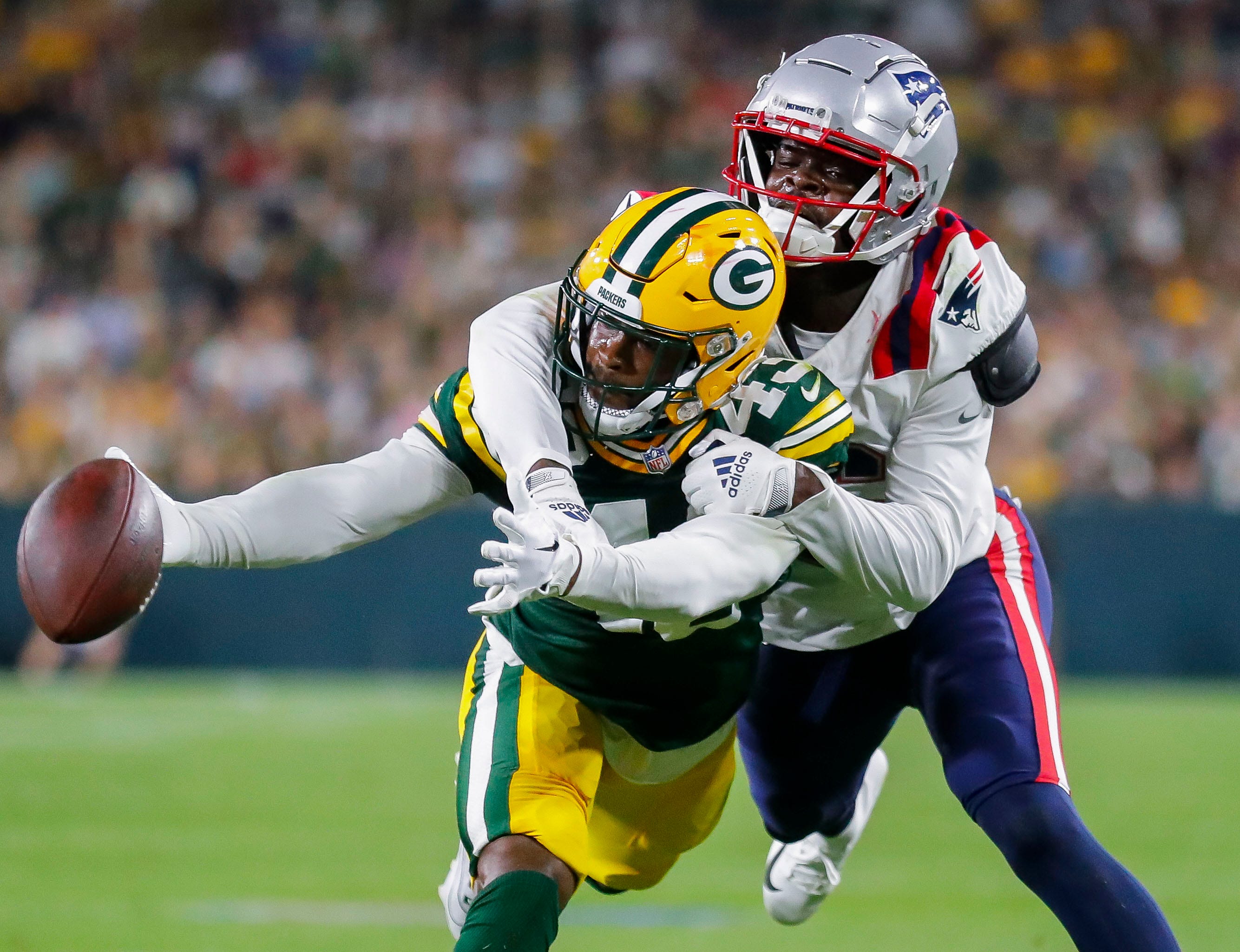 Green Bay Packers cornerback Kiondre Thomas (43) breaks up a pass intended for New England Patriots wide receiver Malik Cunningham (16) during their preseason football game Saturday, August 19, 2023, at Lambeau Field in Green Bay.