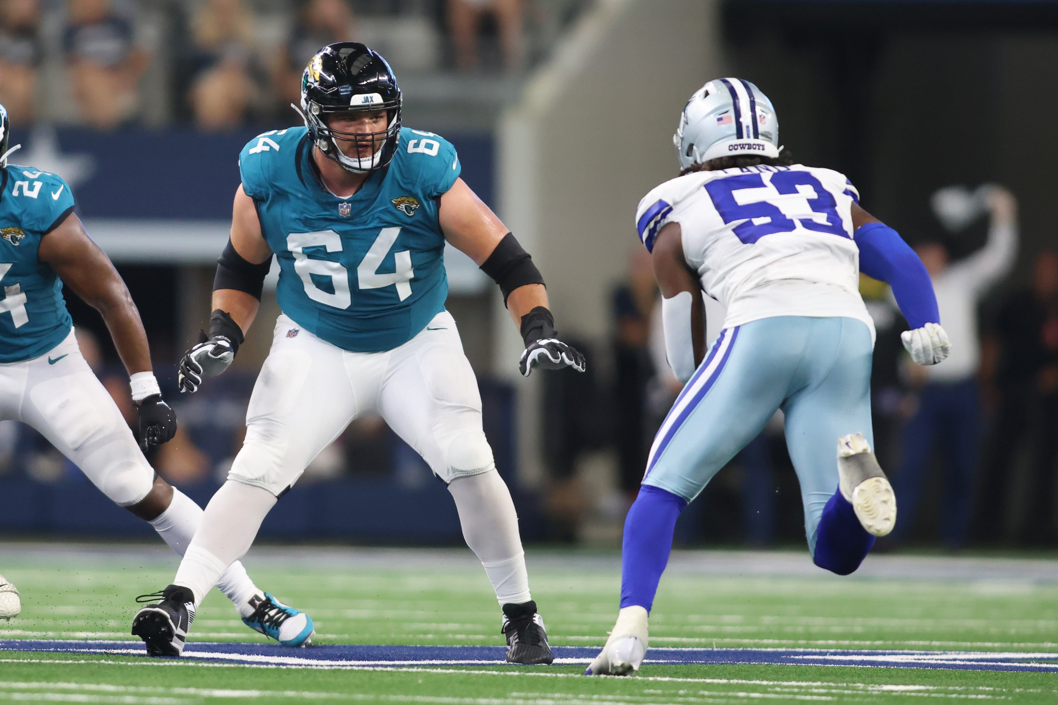 Aug 12, 2023; Arlington, Texas, USA; Jacksonville Jaguars offensive tackle Coy Cronk (64) blocks against Dallas Cowboys linebacker Isaiah Land (53) at AT&T Stadium.