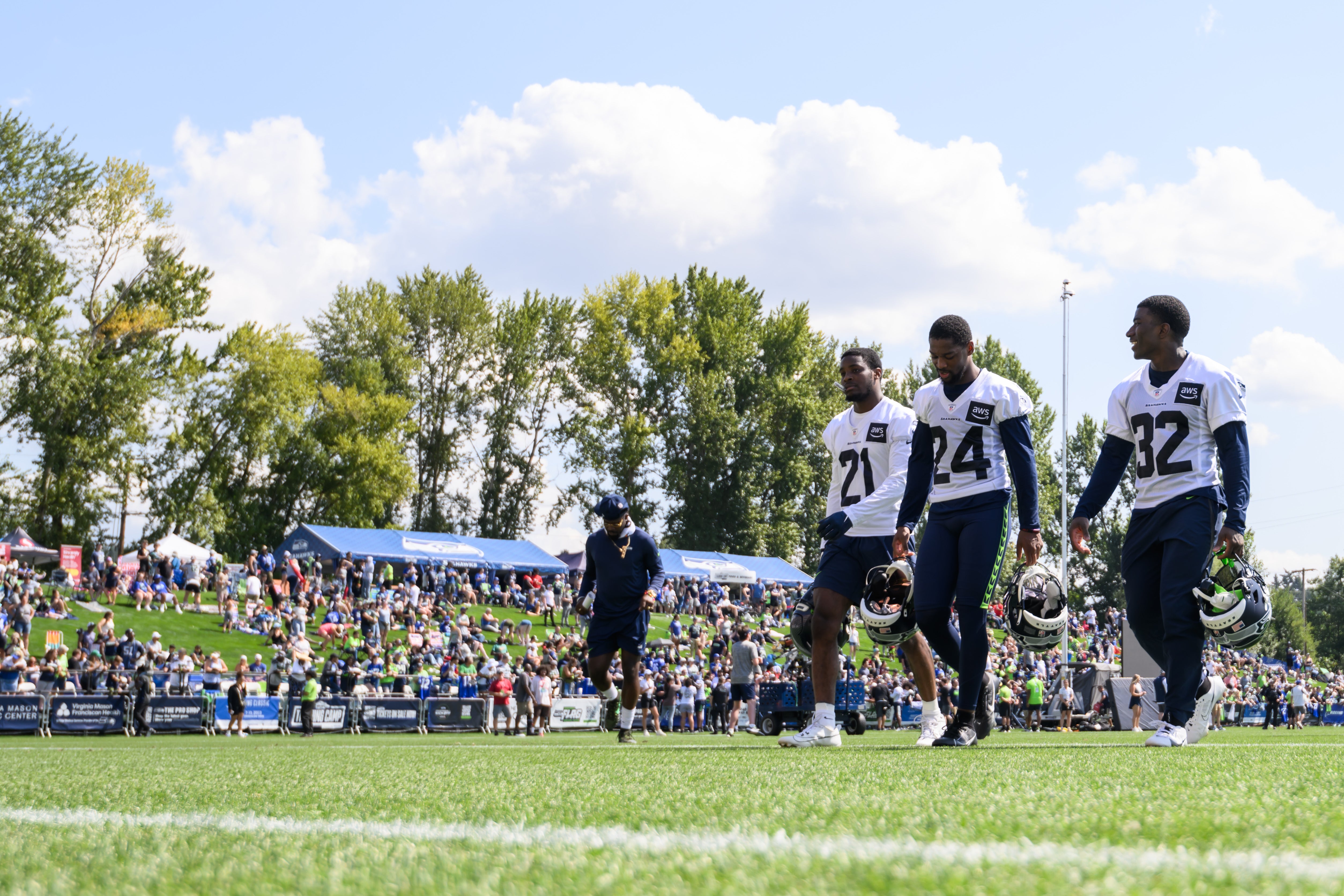 Jul 30, 2023; Renton, WA, USA; Seattle Seahawks cornerback Devon Witherspoon (21) and cornerback Arquon Bush (24) and safety Jerrick Reed II (32) walk off the field after practice at the Virginia Mason Athletic Center. Mandatory Credit: Steven Bisig-USA TODAY Sports