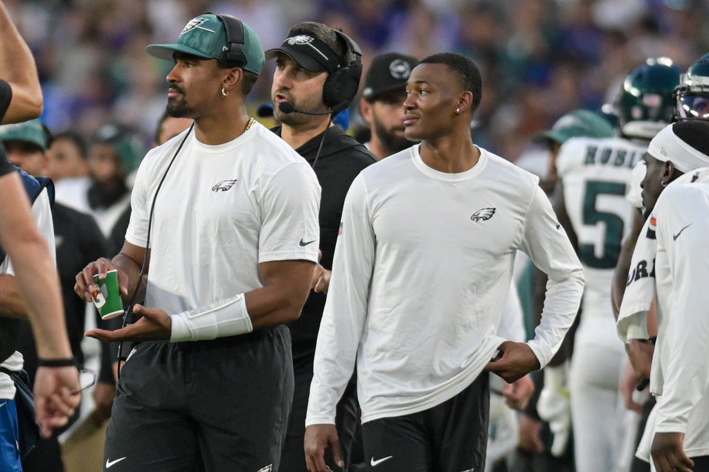 Eagles quarterback Jalen Hurts walks with wide receiver DeVonta Smith.