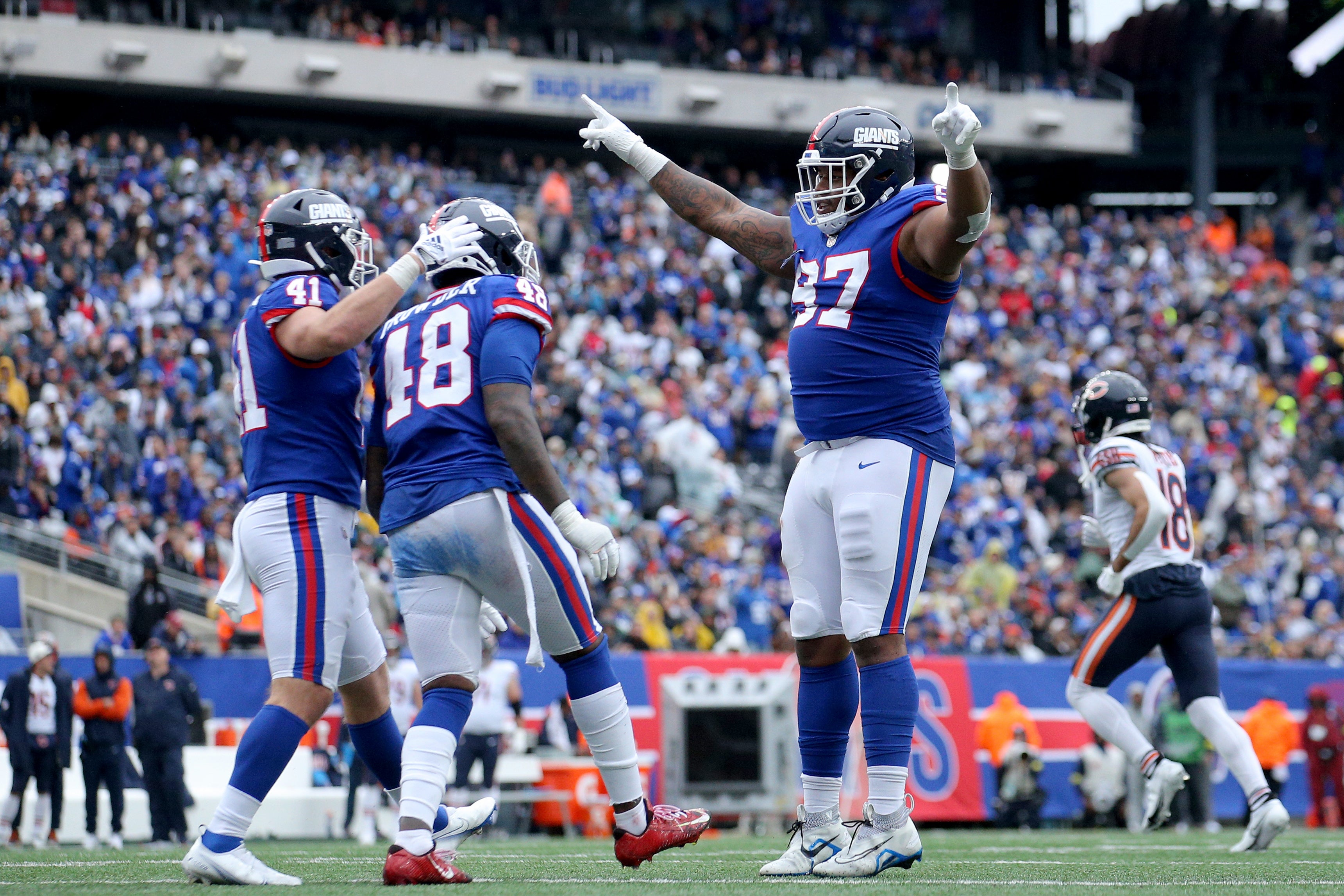 Oct 2, 2022; East Rutherford, New Jersey, USA; New York Giants defensive tackle Dexter Lawrence (97) celebrates with linebacker Micah McFadden (41) and linebacker Tae Crowder (48) during the fourth quarter against the Chicago Bears at MetLife Stadium. Mandatory Credit: Brad Penner-USA TODAY Sports