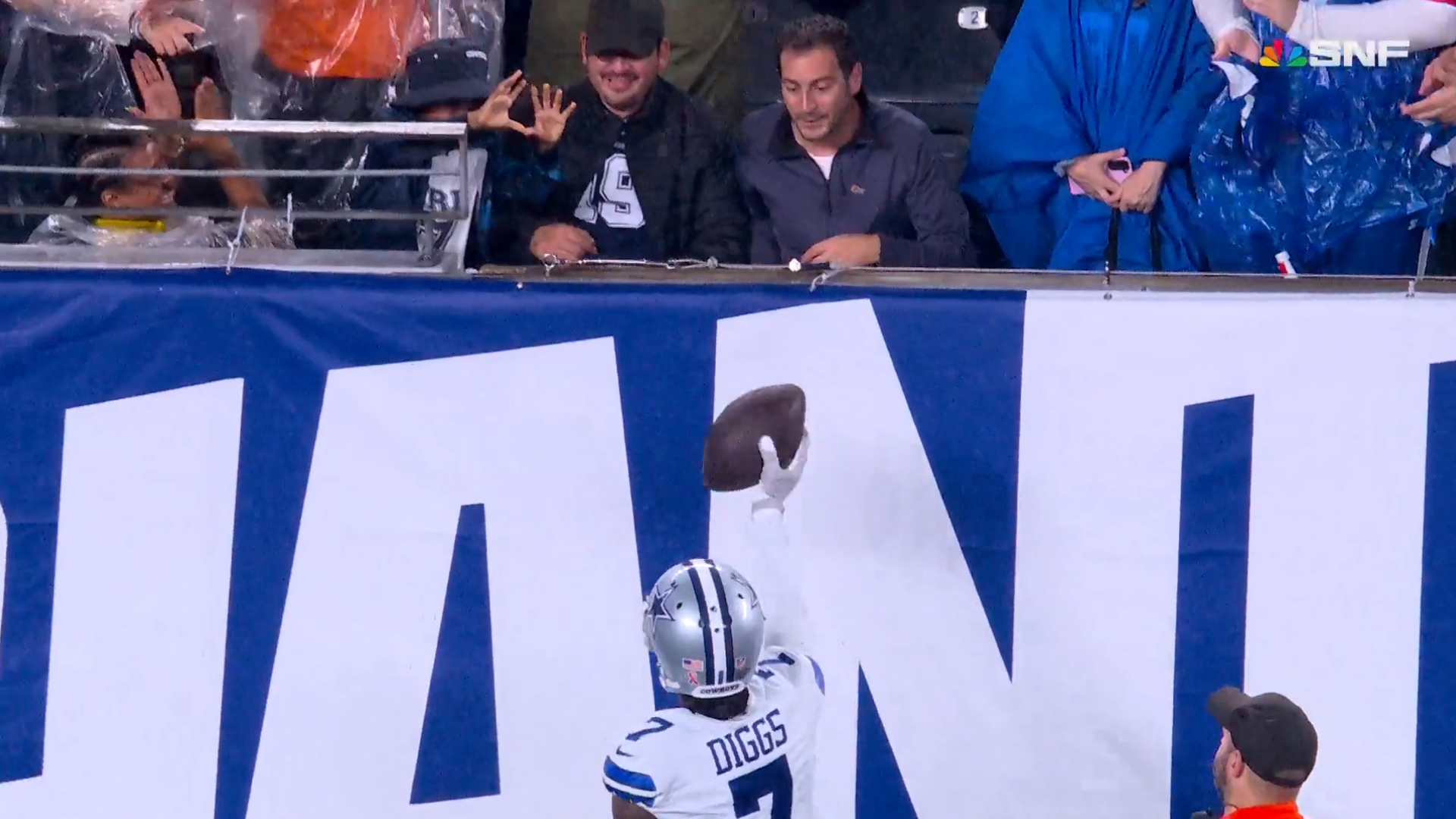 Trevon Diggs hands footballl to his son Aaiden Diggs after big defensive takeaway during Dallas Cowboys' 40-0 win over the New York Giants.