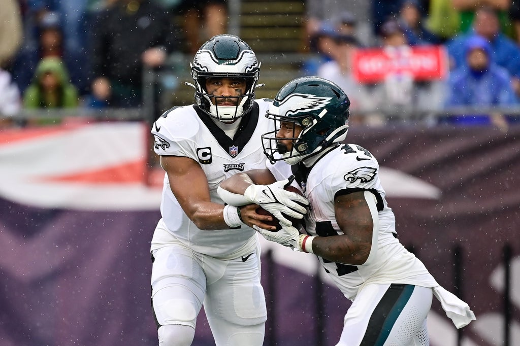 Eagles quarterback Jalen Hurts hands to ball off to running back Kenneth Gainwell