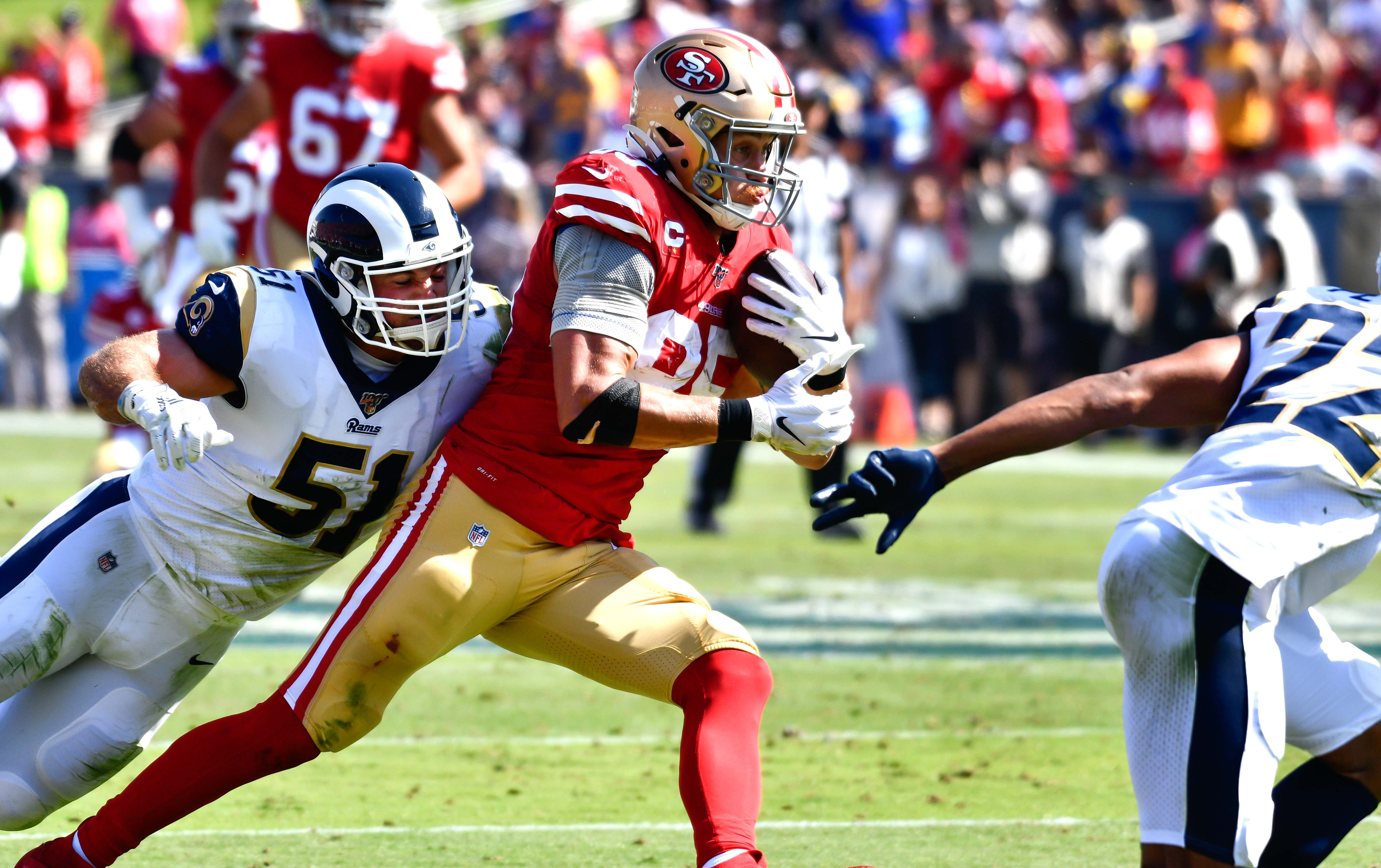 Oct 13, 2019; Los Angeles, CA, USA; Los Angeles Rams linebacker Troy Reeder (51) tries to tackle San Francisco 49ers tight end George Kittle (85) as he heads upfield with a pass during the first half against the Los Angeles Rams at Los Angeles Memorial Coliseum. Mandatory Credit: Robert Hanashiro-USA TODAY Sports