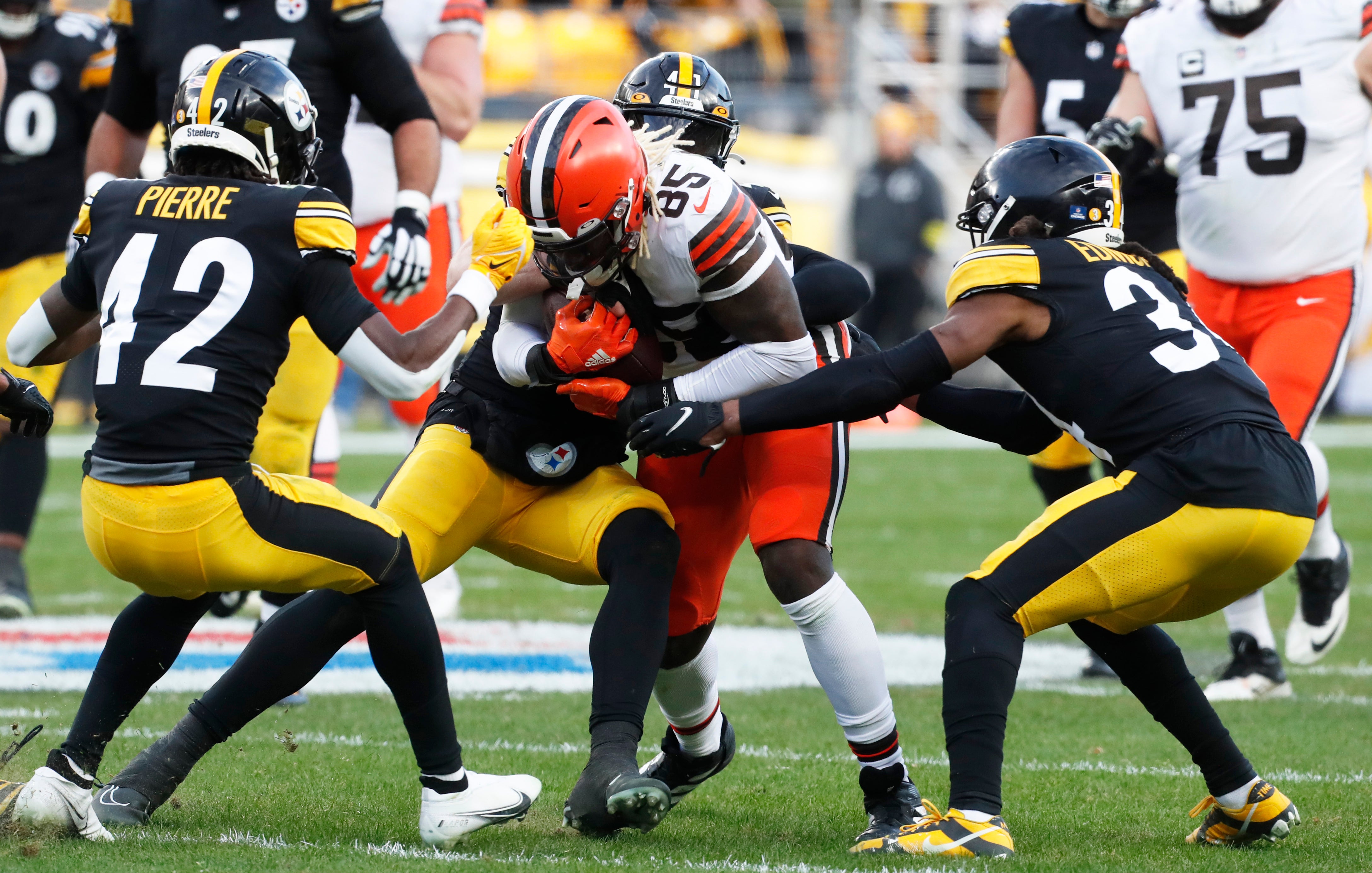 Jan 8, 2023; Pittsburgh, Pennsylvania, USA; Cleveland Browns tight end David Njoku (85) is tackled after a catch by Pittsburgh Steelers cornerback James Pierre (42) and linebacker Robert Spillane (41) and safety Terrell Edmunds (34) during the fourth quarter at Acrisure Stadium. Pittsburgh won 28-14. Mandatory Credit: Charles LeClaire-USA TODAY Sports  
