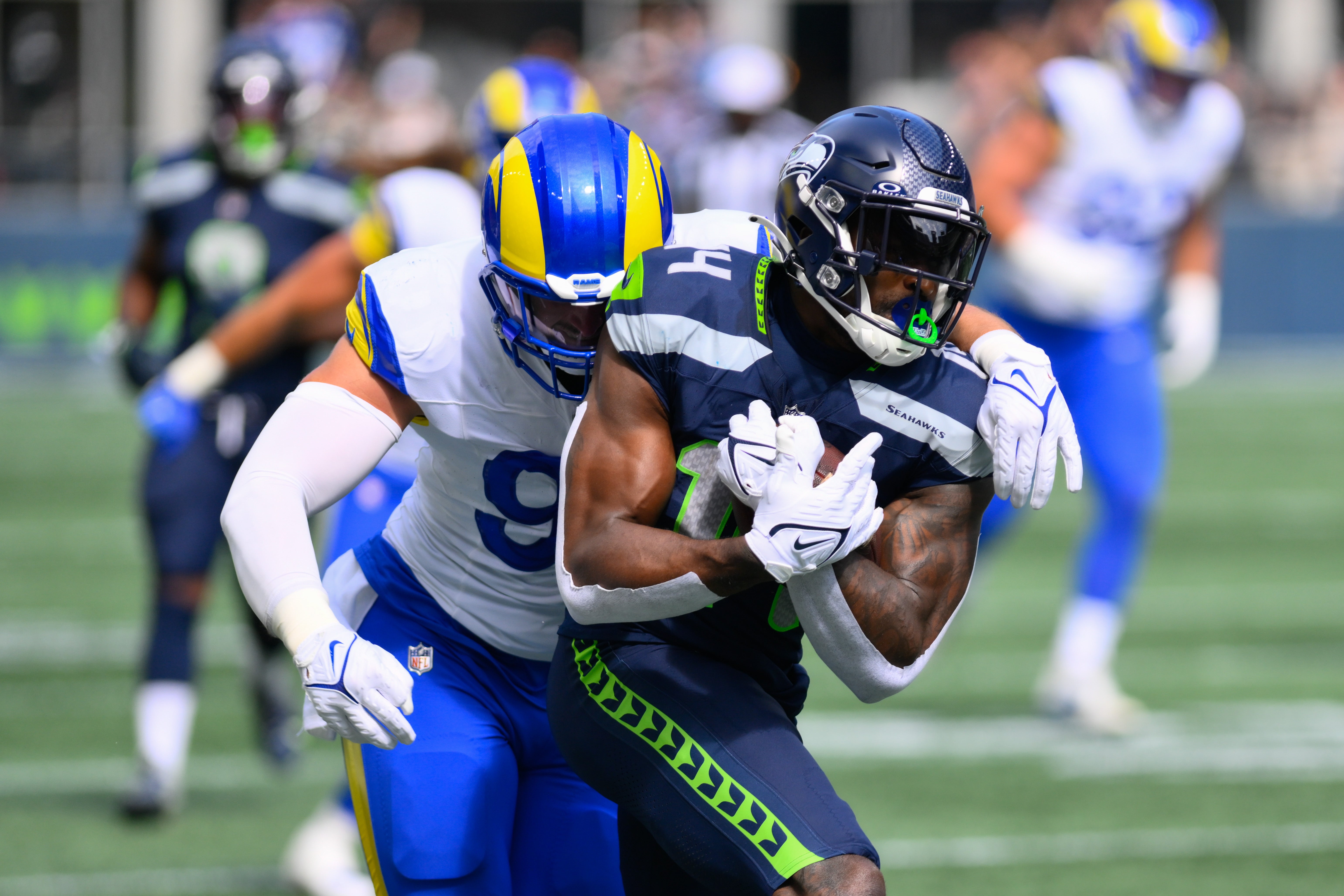 Sep 10, 2023; Seattle, Washington, USA; Seattle Seahawks wide receiver DK Metcalf (14) protects the ball from Los Angeles Rams linebacker Michael Hoecht (97) during the first half at Lumen Field. Mandatory Credit: Steven Bisig-USA TODAY Sports