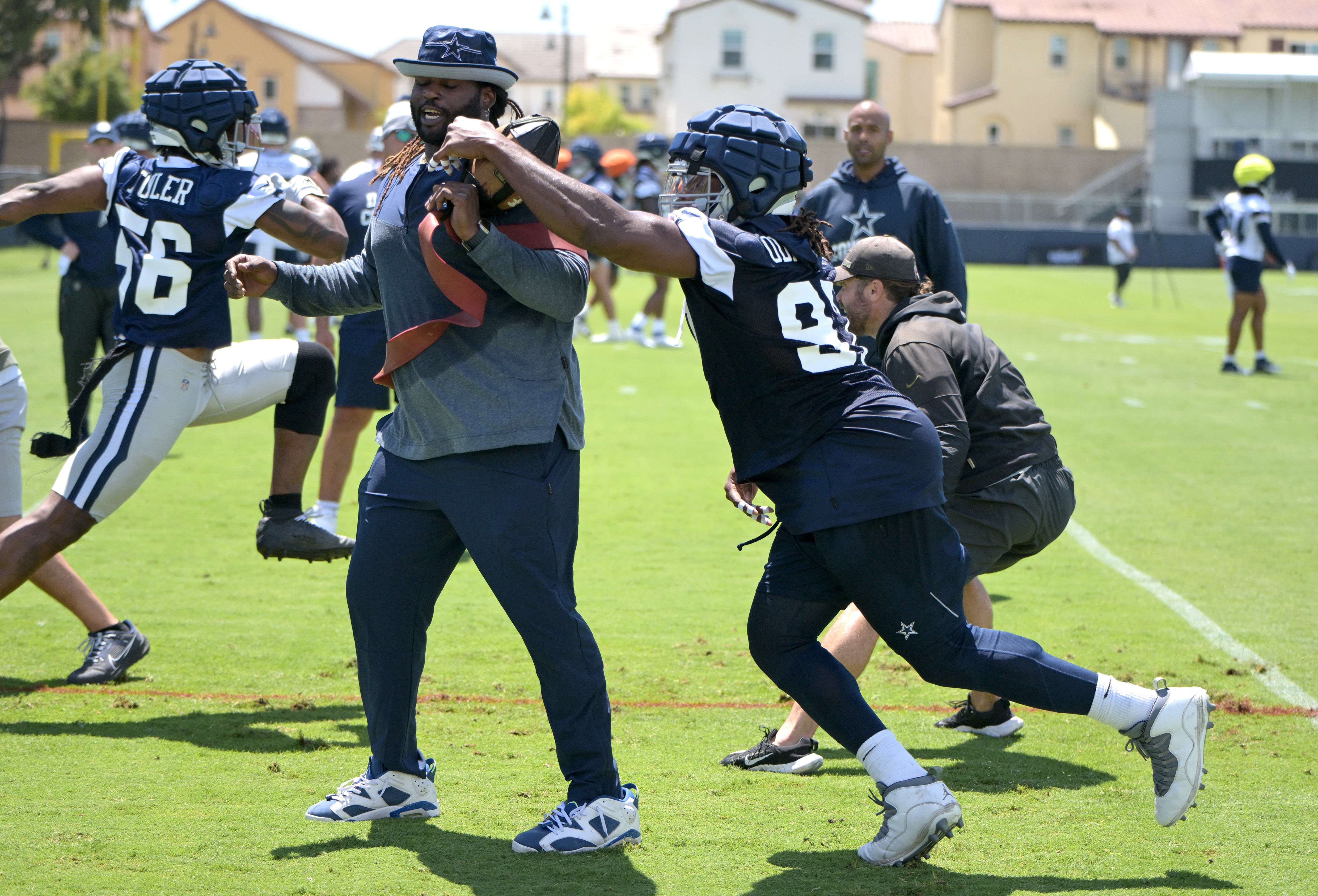 Dallas Cowboys defensive end DeMarcus Lawrence (90) reaches around assistant defensive line coach Sharrif Floyd during training camp drills at River Ridge Playing Fields in Oxnard, CA. Mandatory Credit: Jayne Kamin-Oncea-USA TODAY Sports