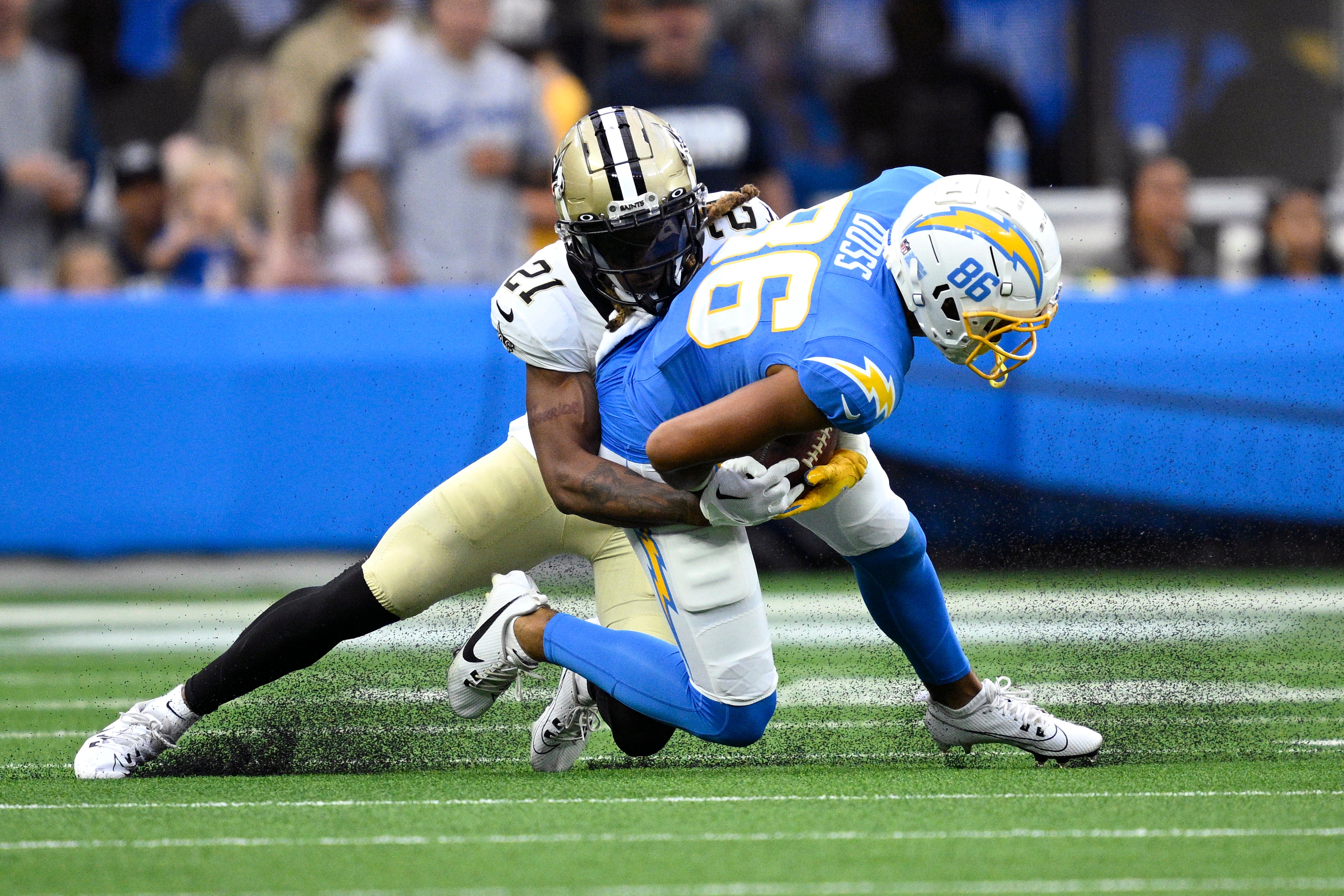 Aug 20, 2023; Inglewood, California, USA; Los Angeles Chargers wide receiver Keelan Doss (86) is tackled by New Orleans Saints cornerback Bradley Roby (21) during the first half at SoFi Stadium. Mandatory Credit: Orlando Ramirez-USA TODAY Sports