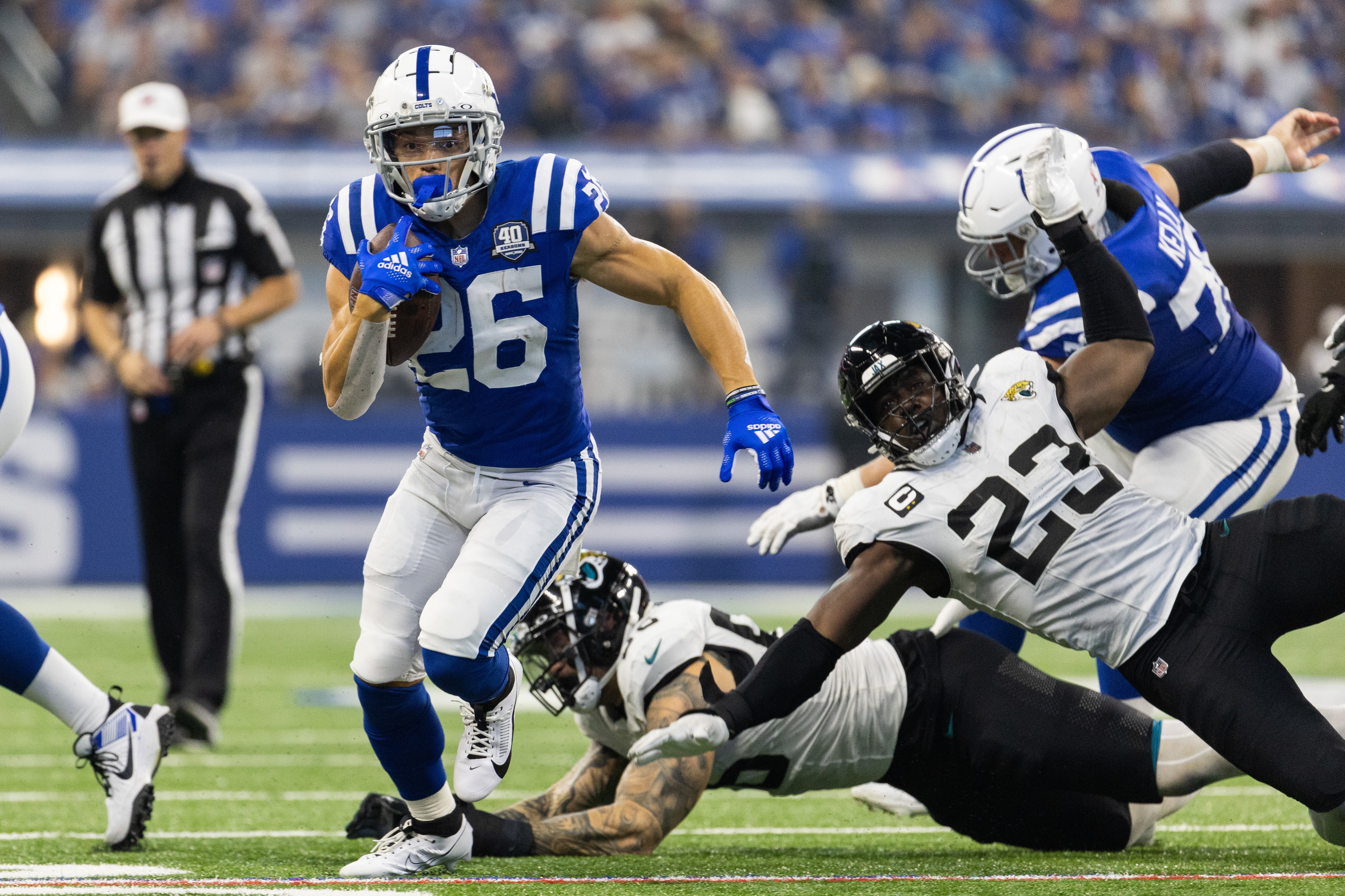 Sep 10, 2023; Indianapolis, Indiana, USA; Indianapolis Colts running back Evan Hull (26) runs the ball while Jacksonville Jaguars linebacker Foyesade Oluokun (23) defends in the second half at Lucas Oil Stadium.
