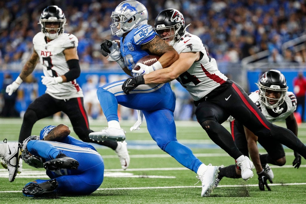 Falcons linebacker Troy Andersen attempts to tackle Lions running back Craig Reynolds