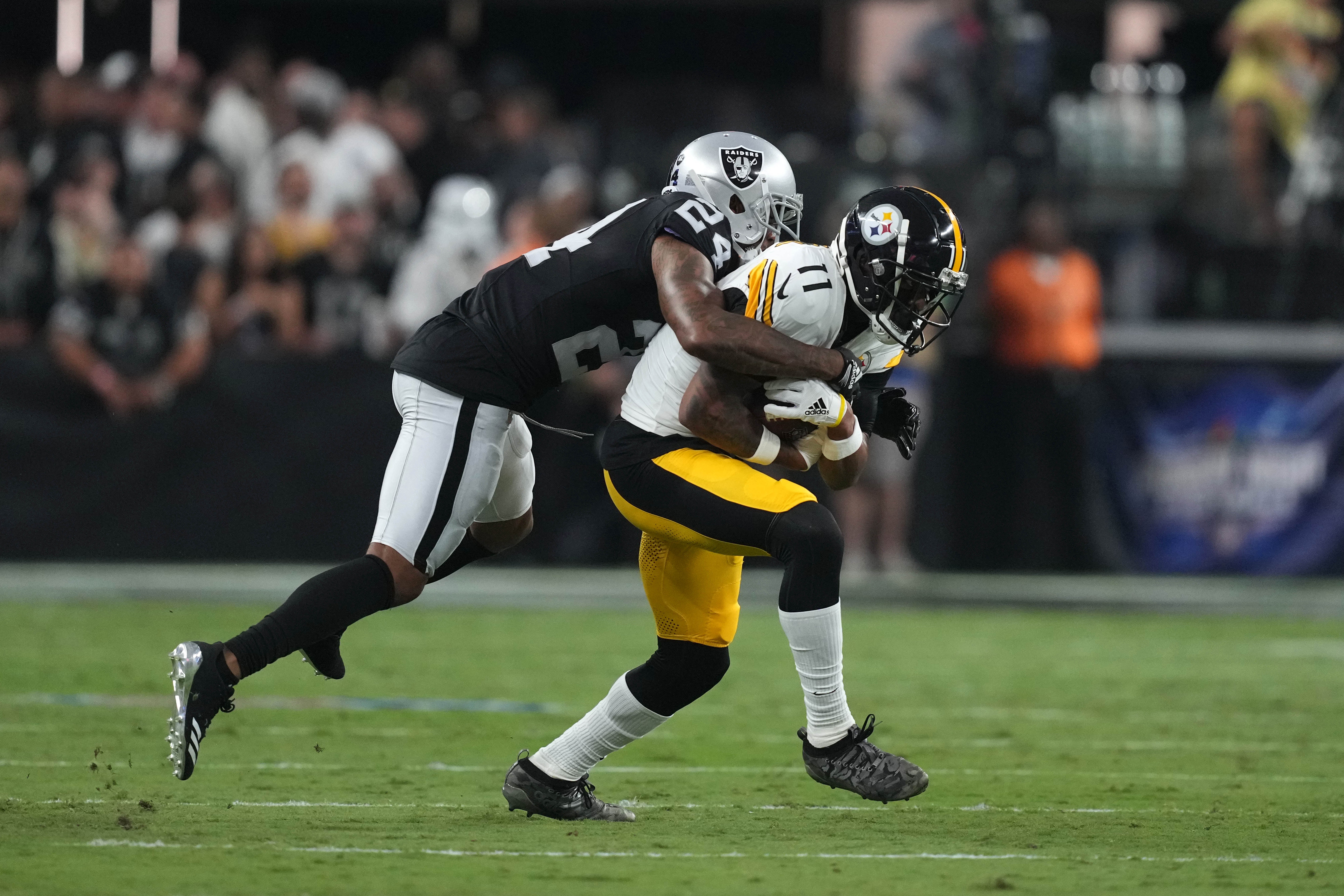 Sep 24, 2023; Paradise, Nevada, USA; Las Vegas Raiders cornerback Marcus Peters (24) tackles Pittsburgh Steelers wide receiver Allen Robinson II (11) in the first half at Allegiant Stadium. Mandatory Credit: Kirby Lee-USA TODAY Sports