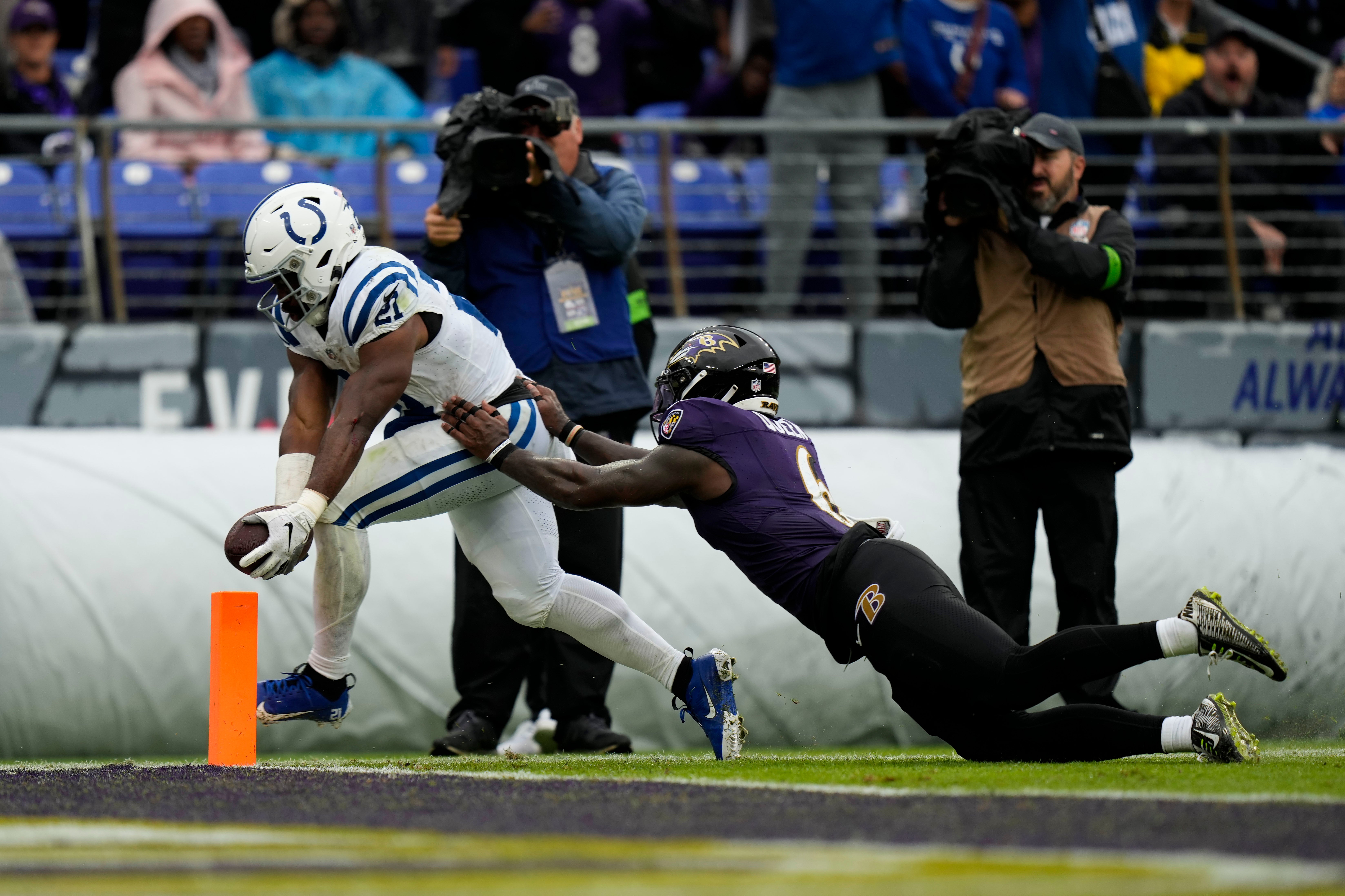 Sep 24, 2023; Baltimore, Maryland, USA; Indianapolis Colts running back Zack Moss (21) scores a touchdown while being defended by Baltimore Ravens linebacker Patrick Queen (6) in the second quarter at M&T Bank Stadium.