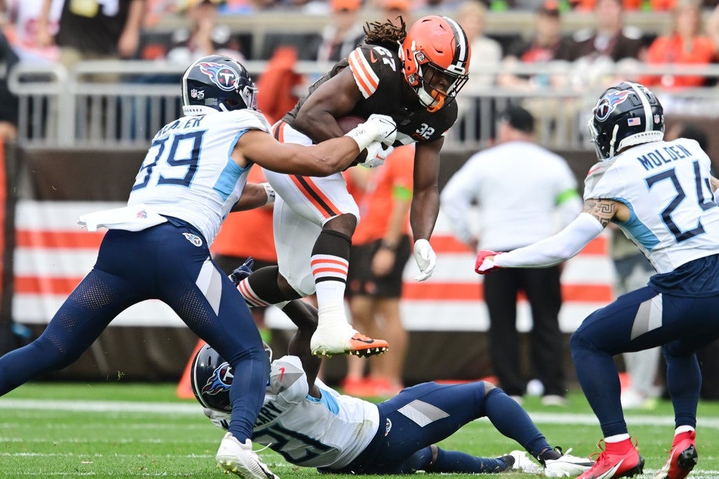 Cleveland Browns running back Kareem Hunt (27) jumps over Tennessee Titans cornerback Roger McCreary (21) during the second half at Cleveland Browns Stadium.