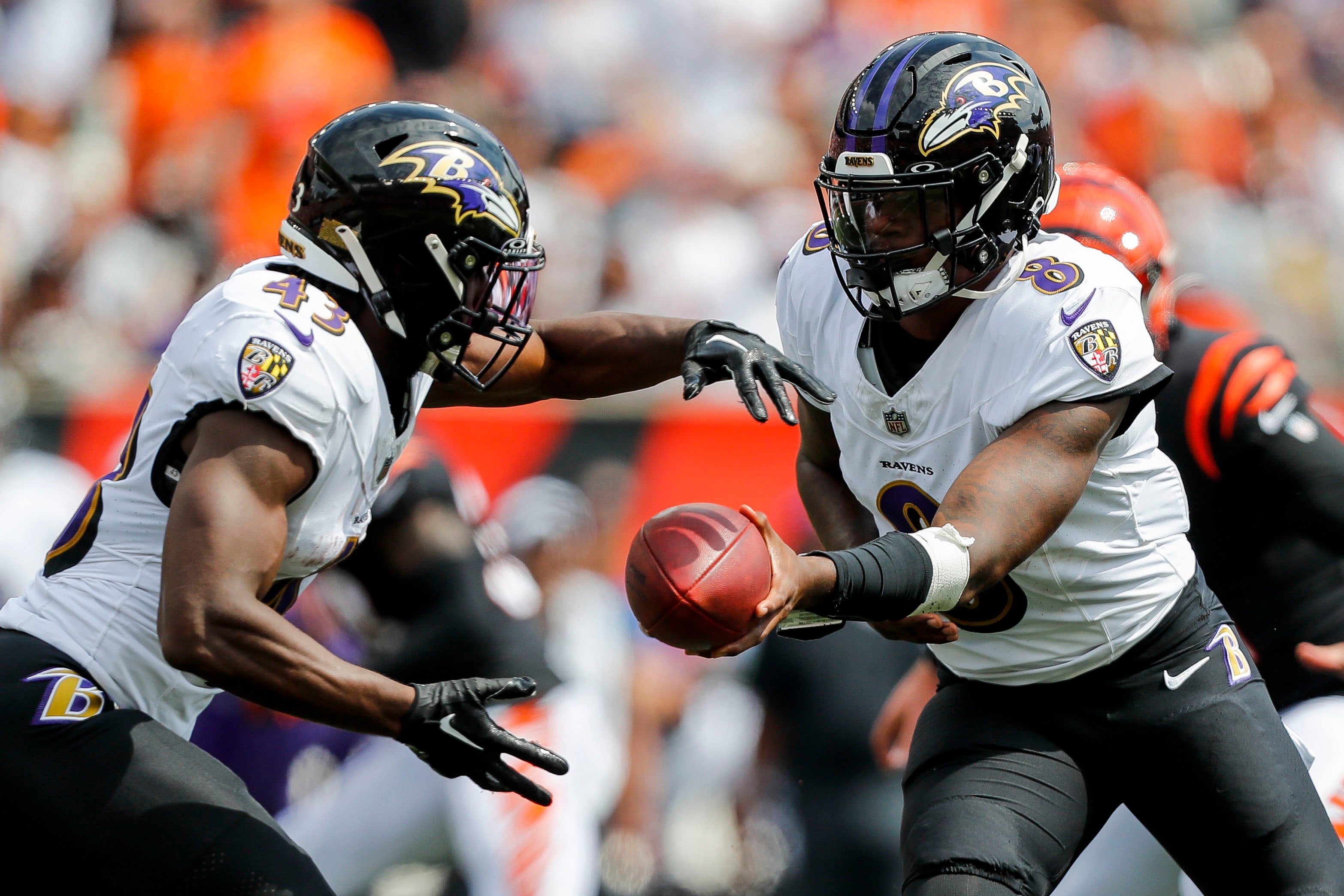 Baltimore Ravens quarterback Lamar Jackson (8) hands the ball off to running back Justice Hill (43) in the first half against the Cincinnati Bengals at Paycor Stadium.