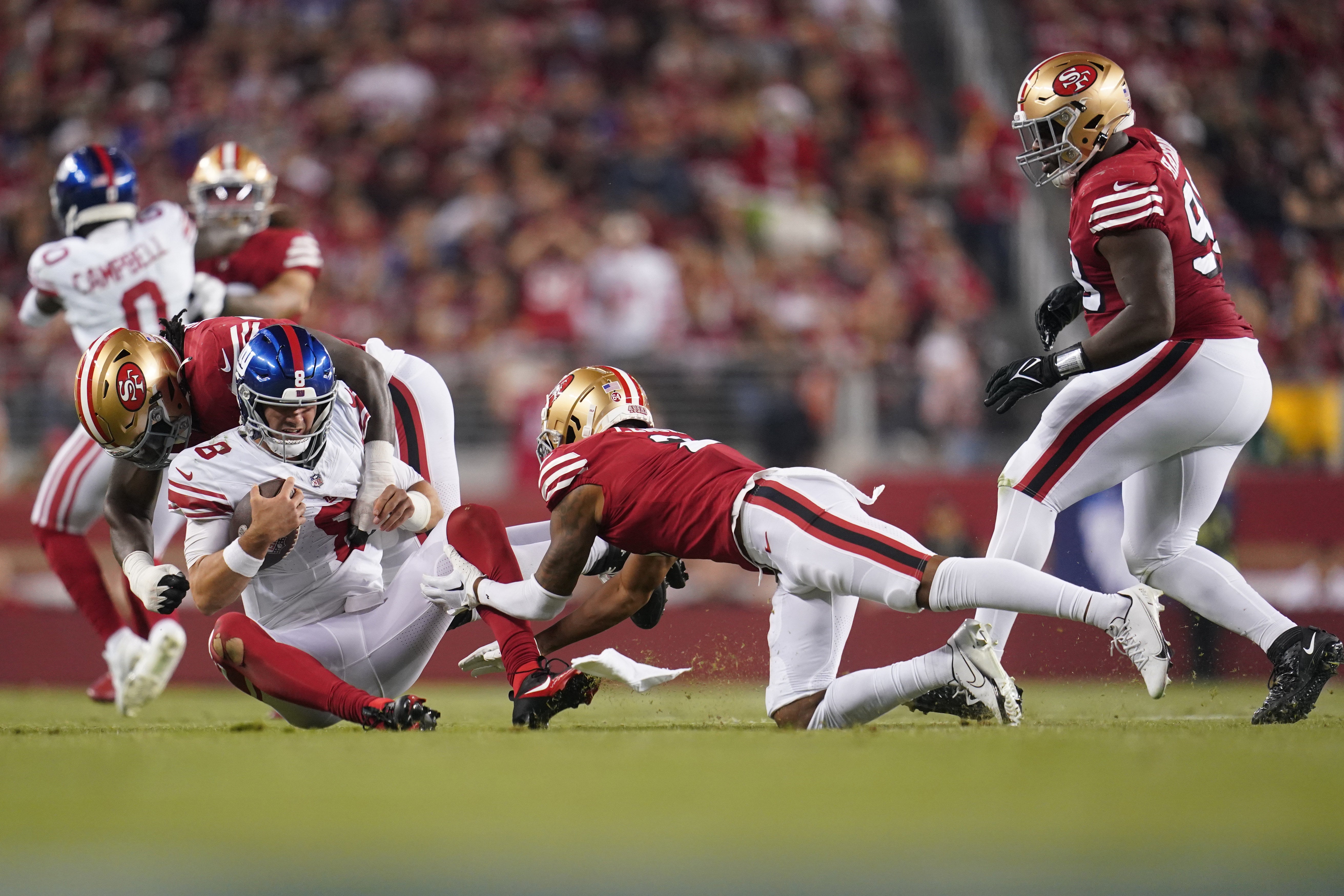 Sep 21, 2023; Santa Clara, California, USA; New York Giants quarterback Daniel Jones (8) is tackled by San Francisco 49ers defensive tackle Javon Kinlaw (99) and cornerback Deommodore Lenoir (2) in the fourth quarter at Levi's Stadium.