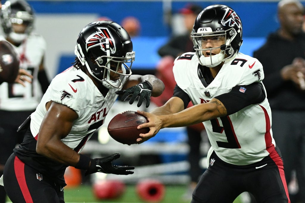 Falcons quarterback Desmond Ridder hands the ball off to running back Bijan Robinson