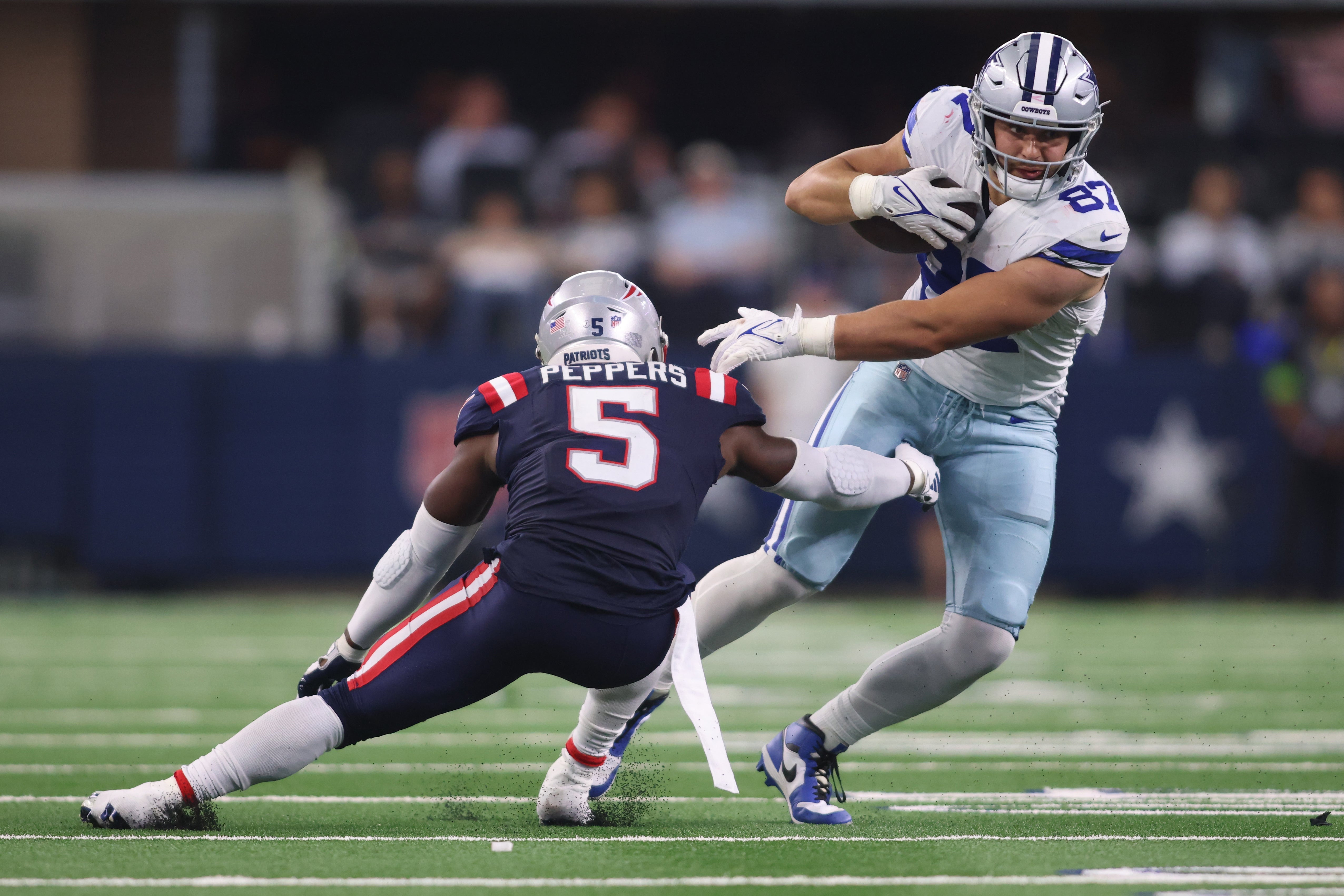 Dallas Cowboys tight end Jake Ferguson (87) attempts to break a tackle of New England Patriots safety Jabrill Peppers (5) in the third quarter at AT&T Stadium. Mandatory Credit: Tim Heitman-USA TODAY Sports