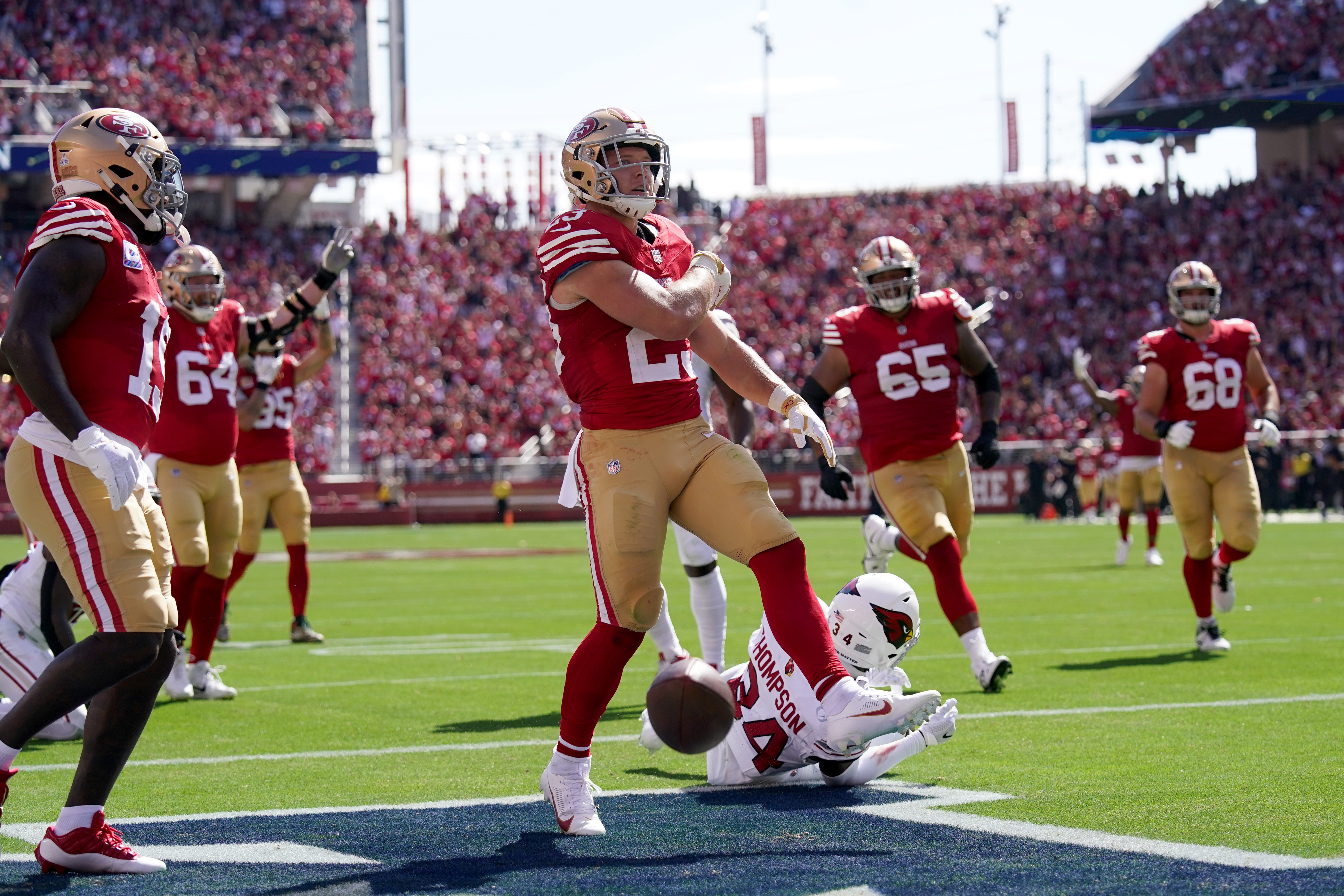 Oct 1, 2023; Santa Clara, California, USA; San Francisco 49ers running back Christian McCaffrey (23) reacts after scoring a touchdown in front of Arizona Cardinals safety Jalen Thompson (34) in the second quarter at Levi's Stadium.