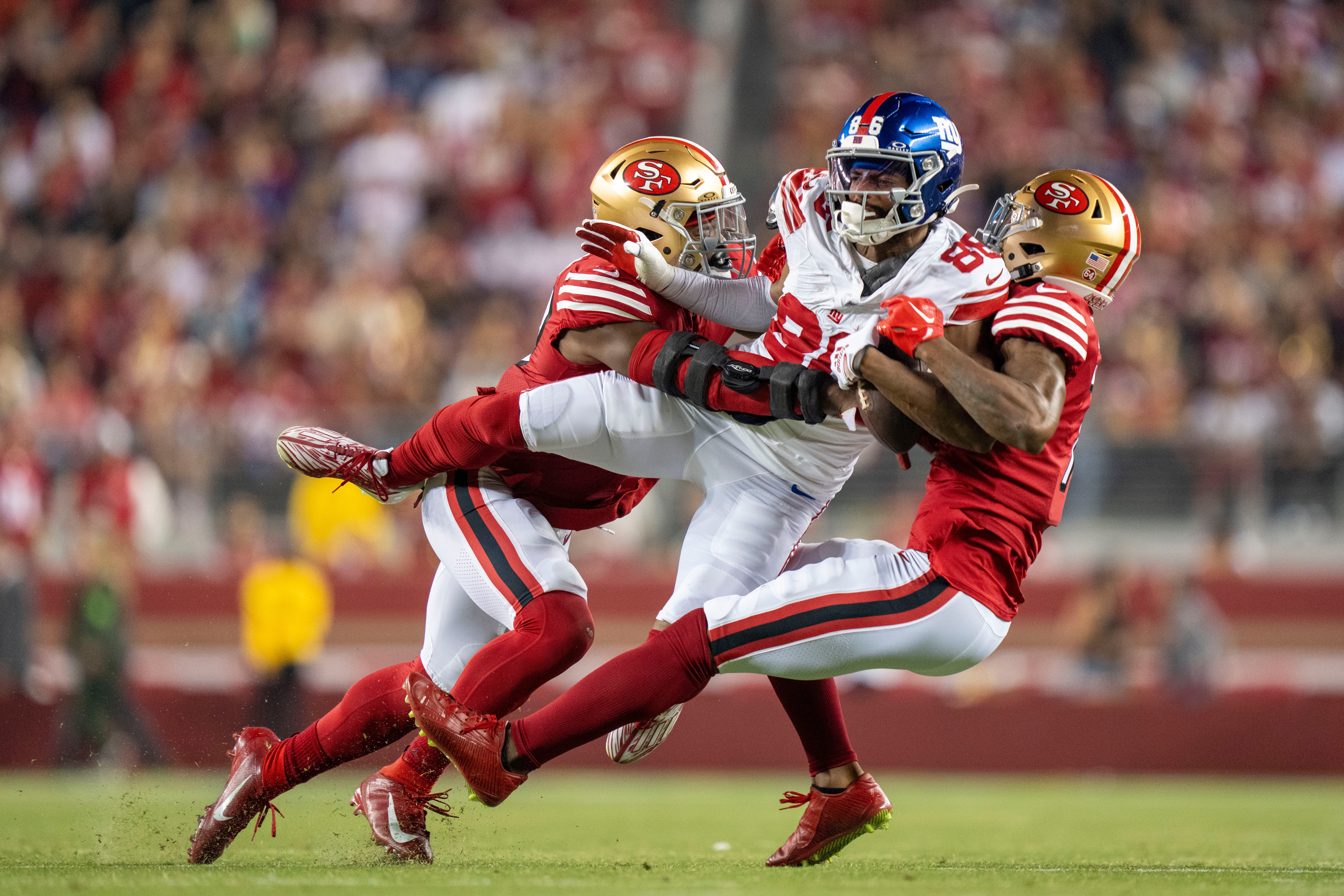 September 21, 2023; Santa Clara, California, USA; New York Giants wide receiver Darius Slayton (86) is tackled by San Francisco 49ers linebacker Dre Greenlaw (57, left) and cornerback Charvarius Ward (7) during the fourth quarter at Levi's Stadium.