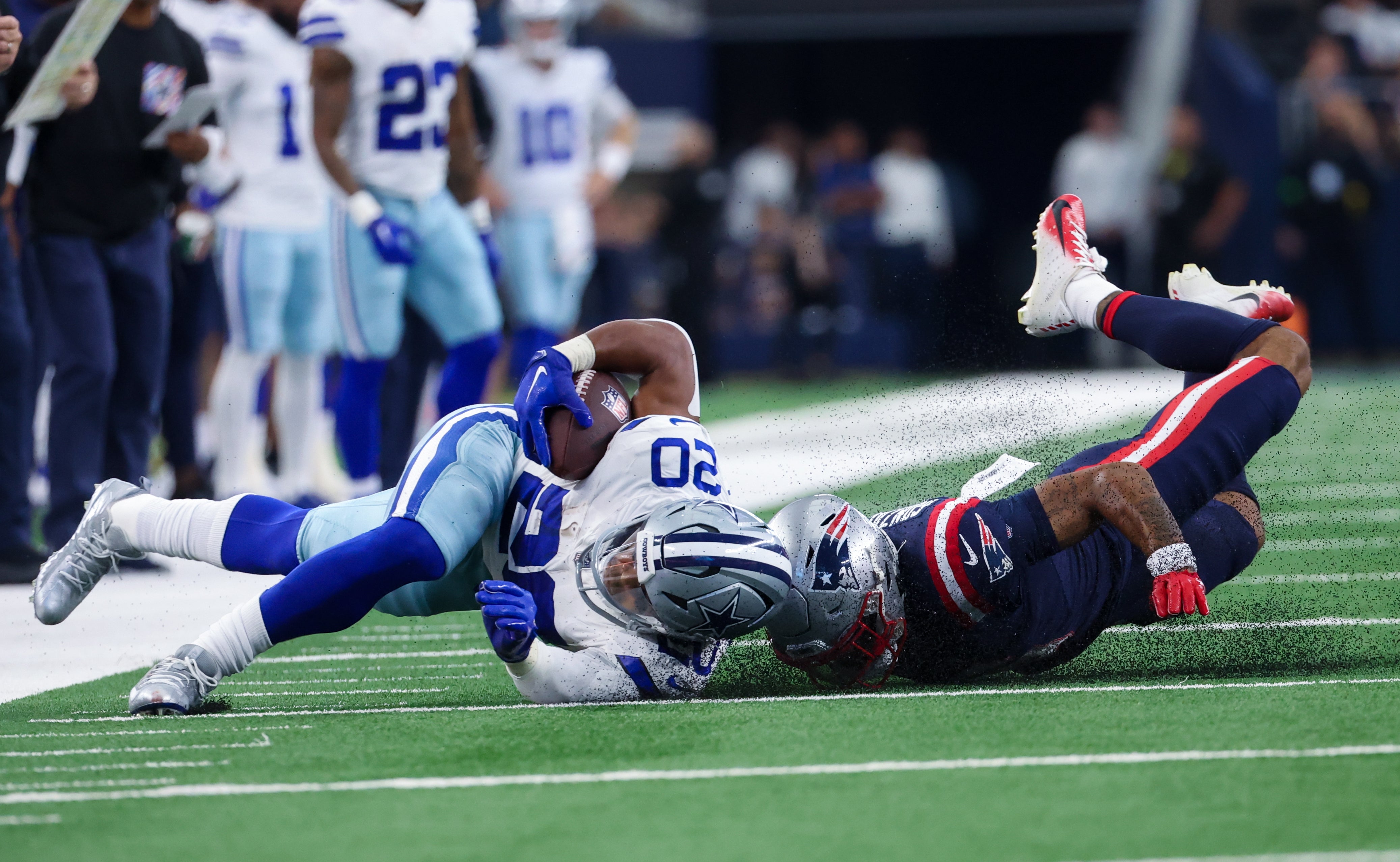 Oct 1, 2023; Arlington, Texas, USA; Dallas Cowboys running back Tony Pollard (20) is tackled by New England Patriots cornerback Christian Gonzalez (6) during the first quarter at AT&T Stadium.