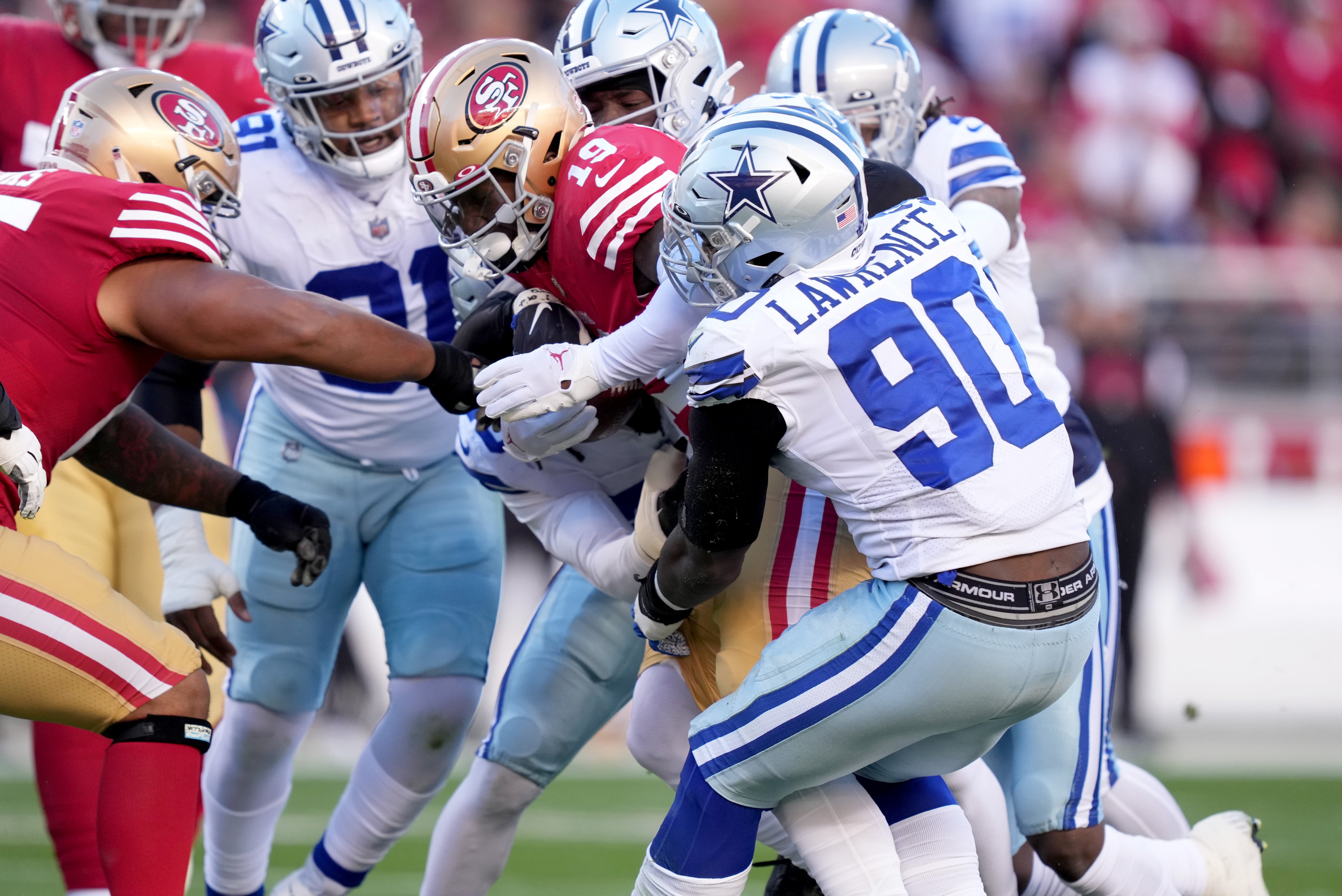 Dallas Cowboys defensive end DeMarcus Lawrence (90) tackles San Francisco 49ers wide receiver Deebo Samuel (19) during the first quarter of a NFC divisional round game at Levi's Stadium. Mandatory Credit: Kyle Terada-USA TODAY Sports