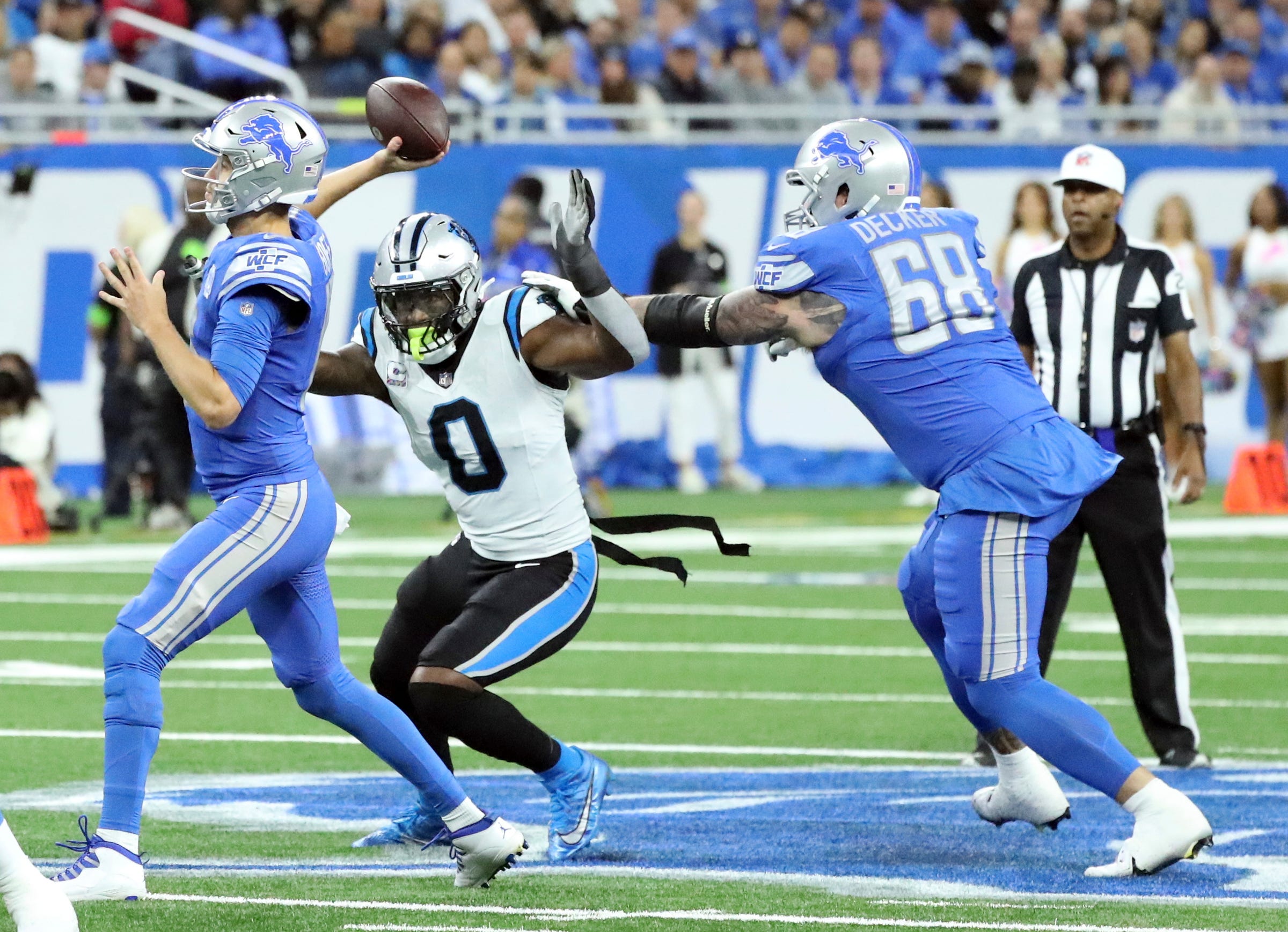 Detroit Lions quarterback Jared Goff (16) passes against the Carolina Panthers as Carolina Panthers linebacker Brian Burns (0) rushes during first-half action at Ford Field in Detroit on Sunday, Oct, 8, 2023.  
